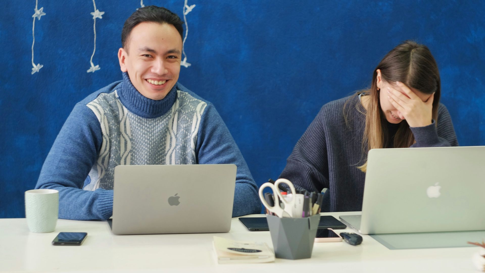 woman in gray sweater using silver macbook