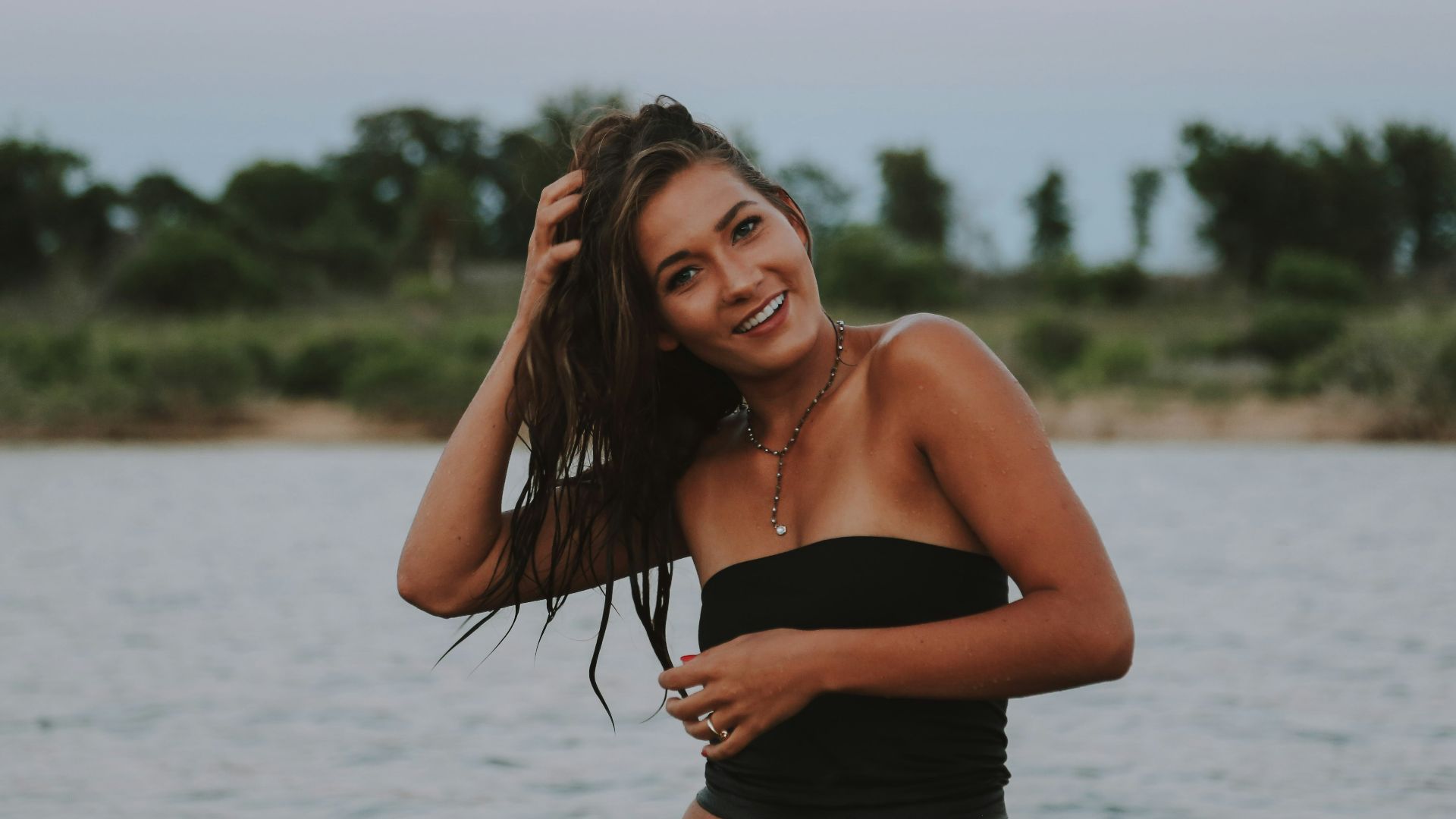 woman wearing black strapless tops near body of water