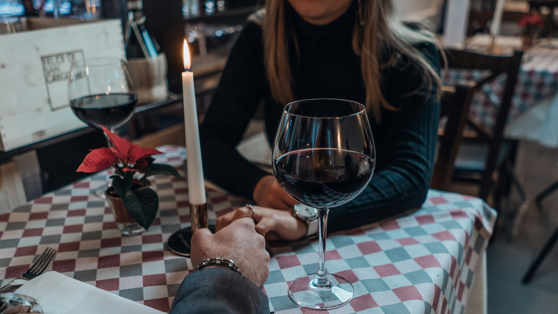 woman wearing black sweater holding hand with man wearing gray suit jacket