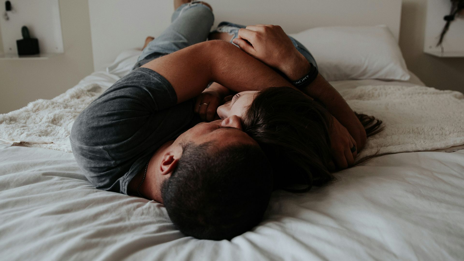 A man and woman cuddling together in bed.