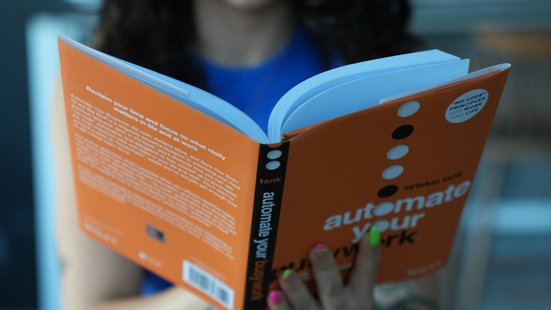 a woman sitting at a table reading a book