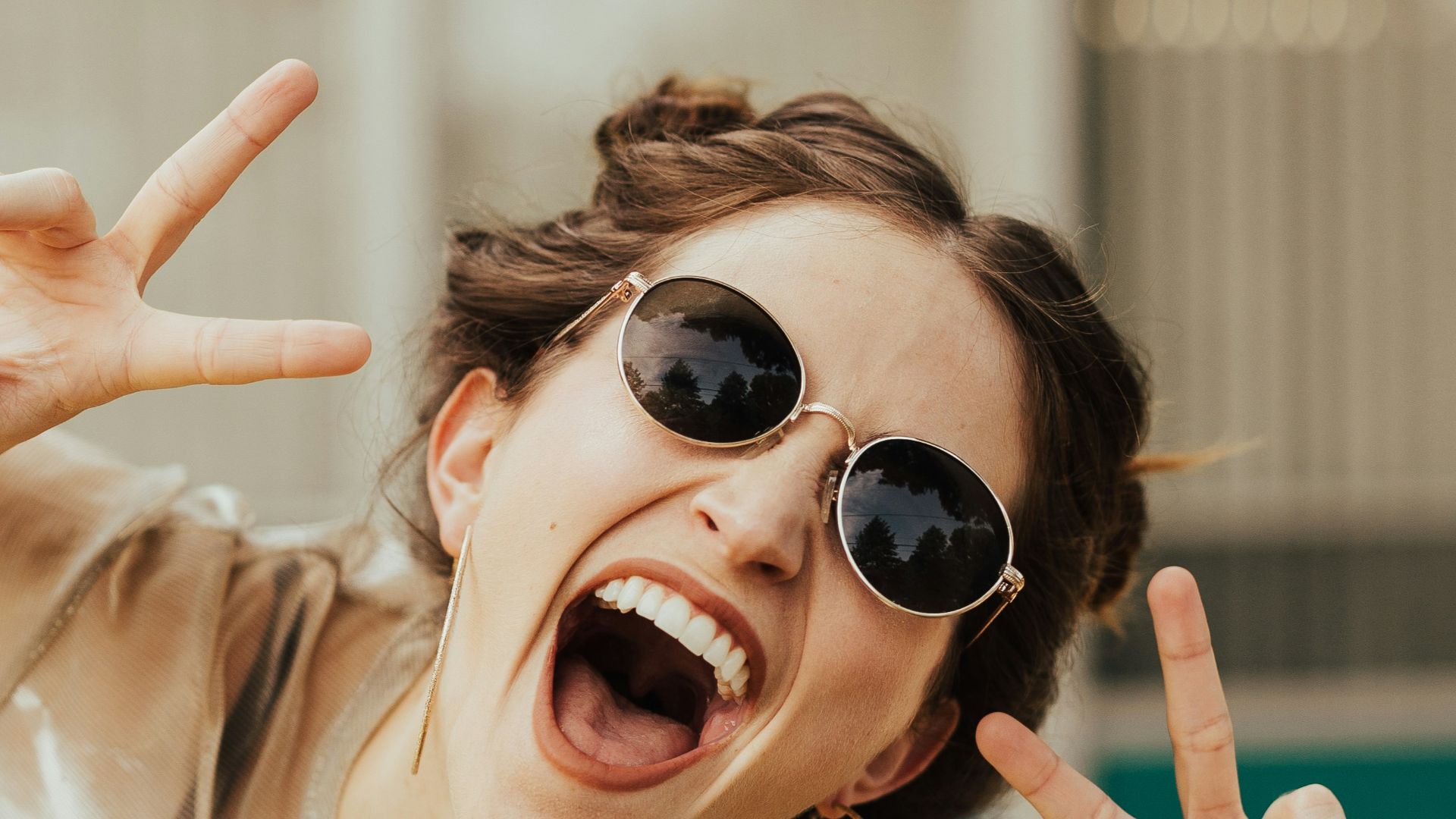 selective focus photography of jolly woman using peace hand gesture