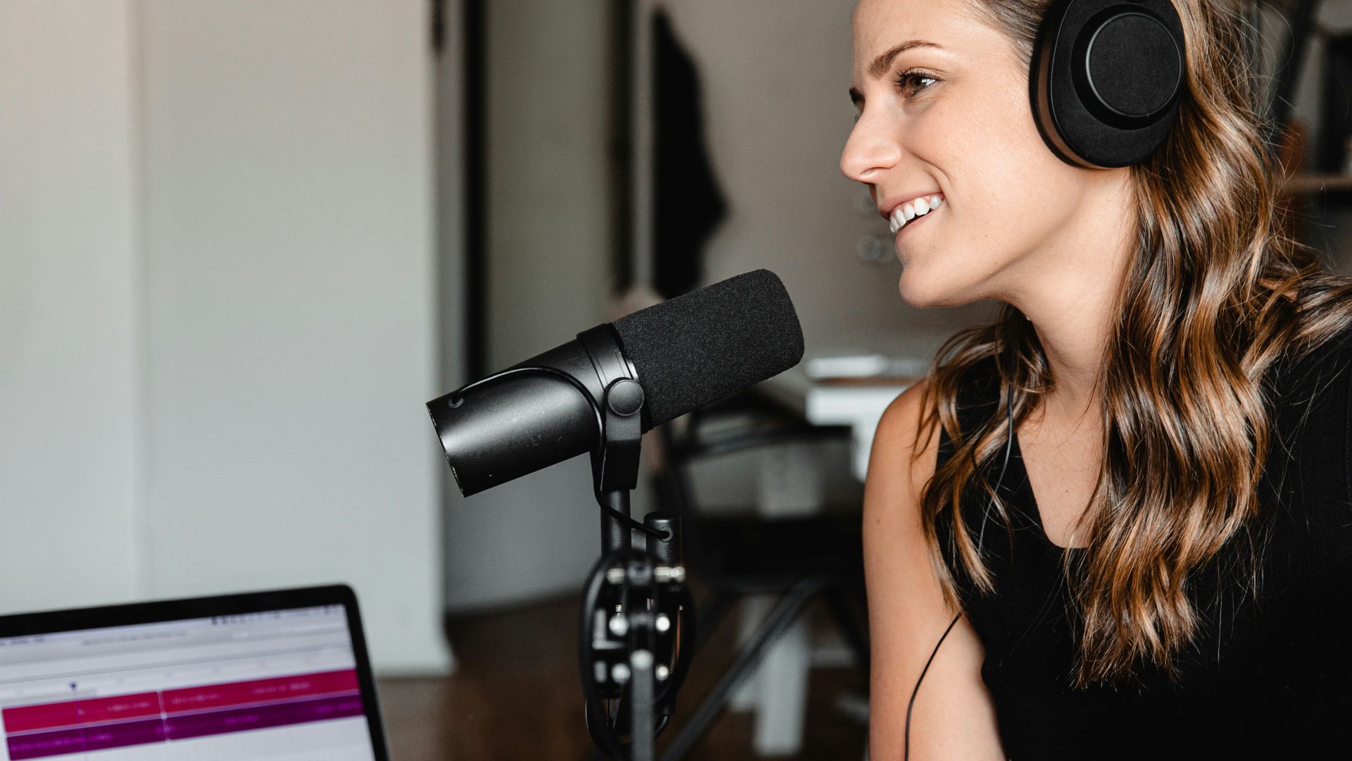 woman in black tank top sitting on chair in front of microphone