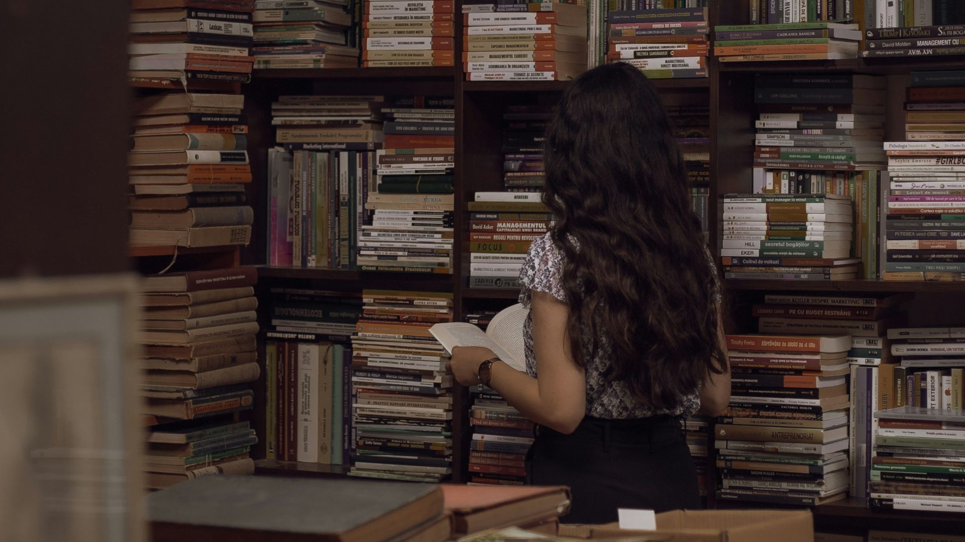 woman in black tank top sitting on brown wooden chair