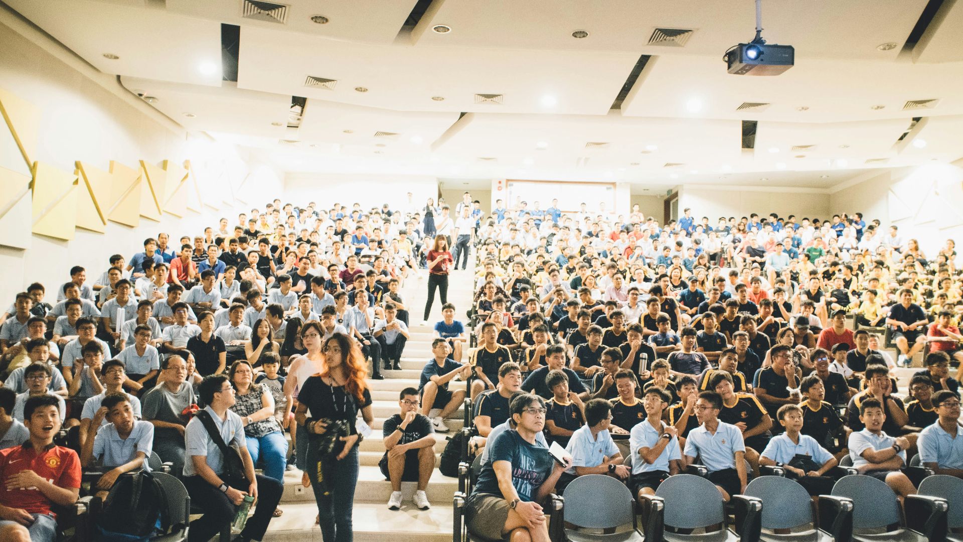 woman wearing black crew-neck dress walking near the chair