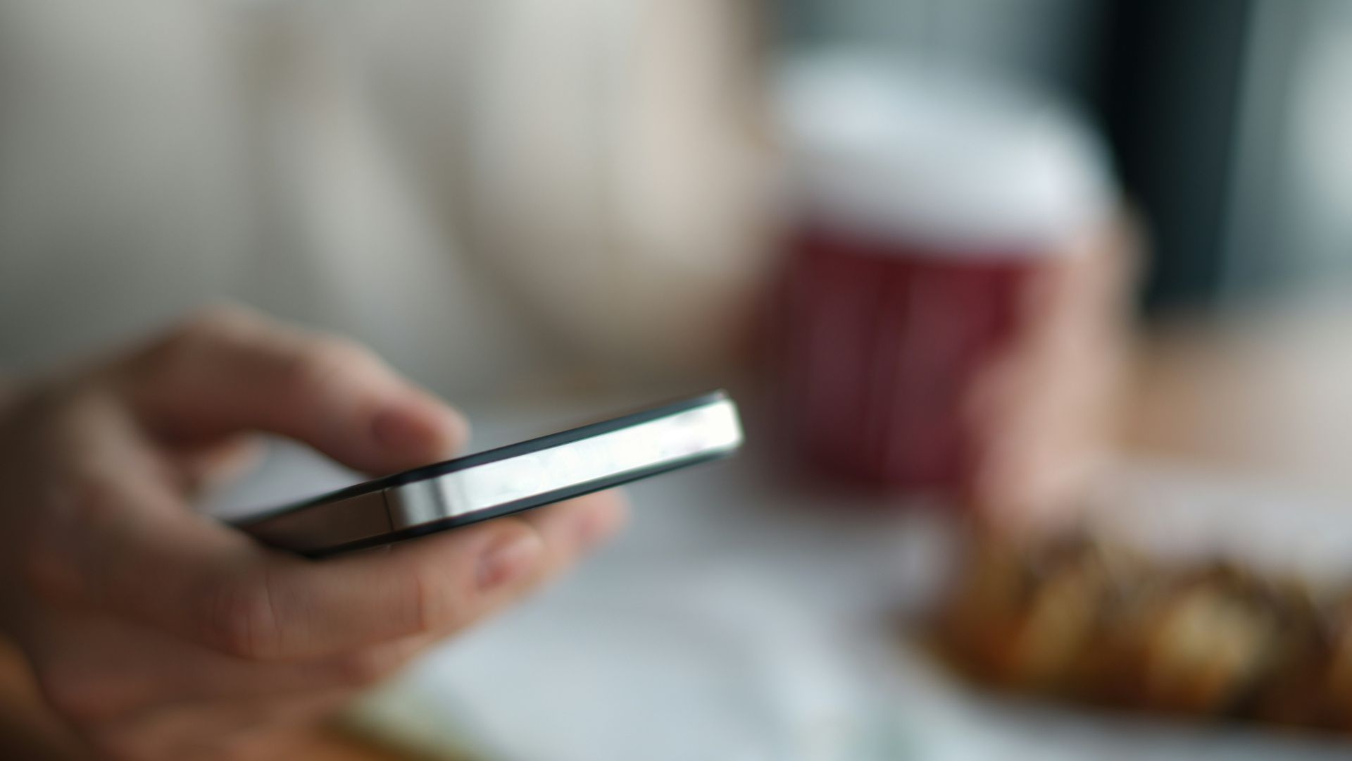 selective focus photography of person holding gray phone