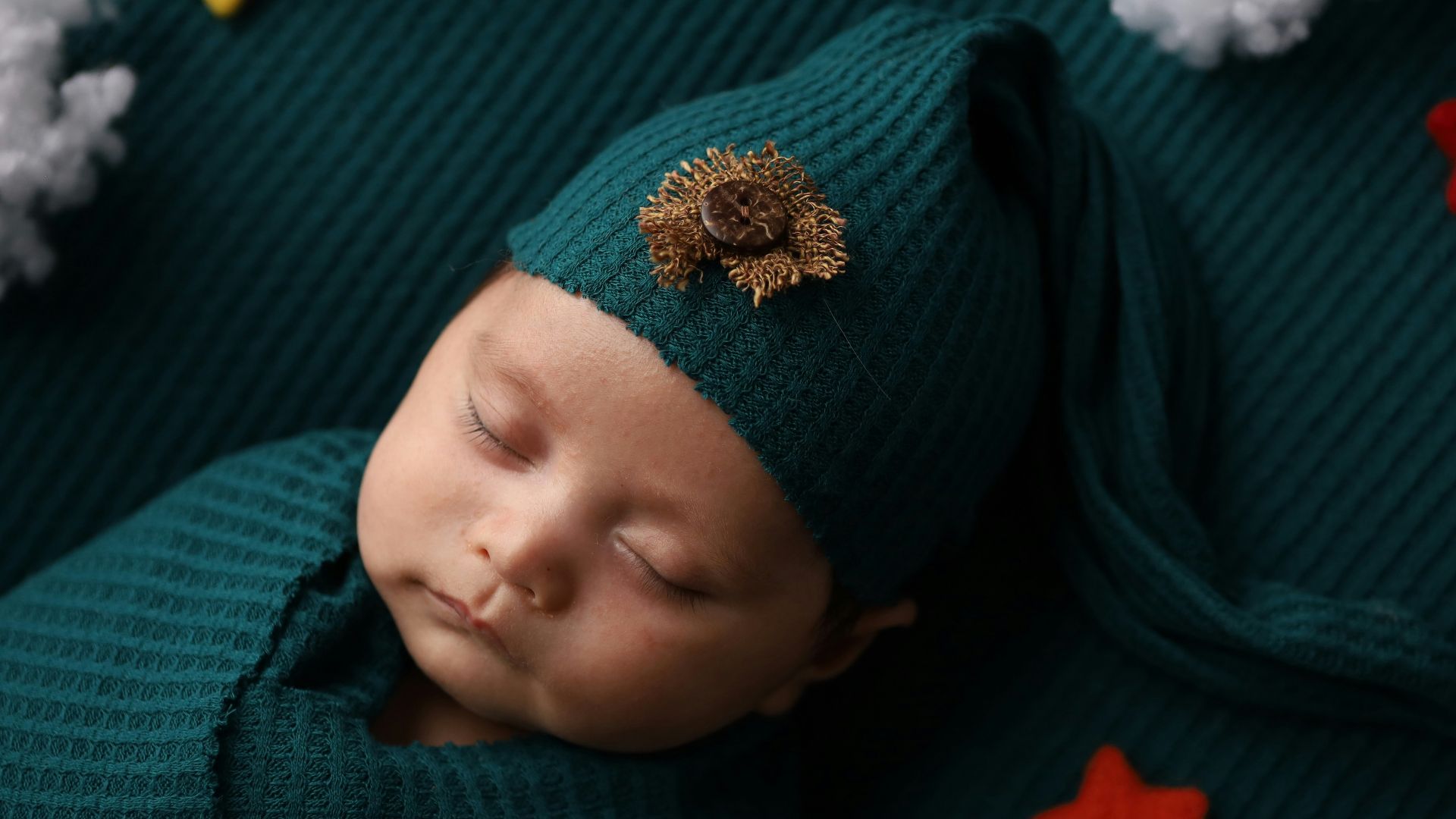 a newborn baby wearing a green hat and green sweater