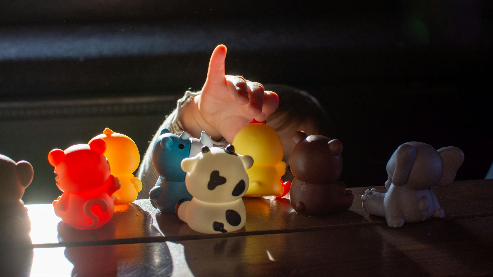 a baby reaching for a toy on a table