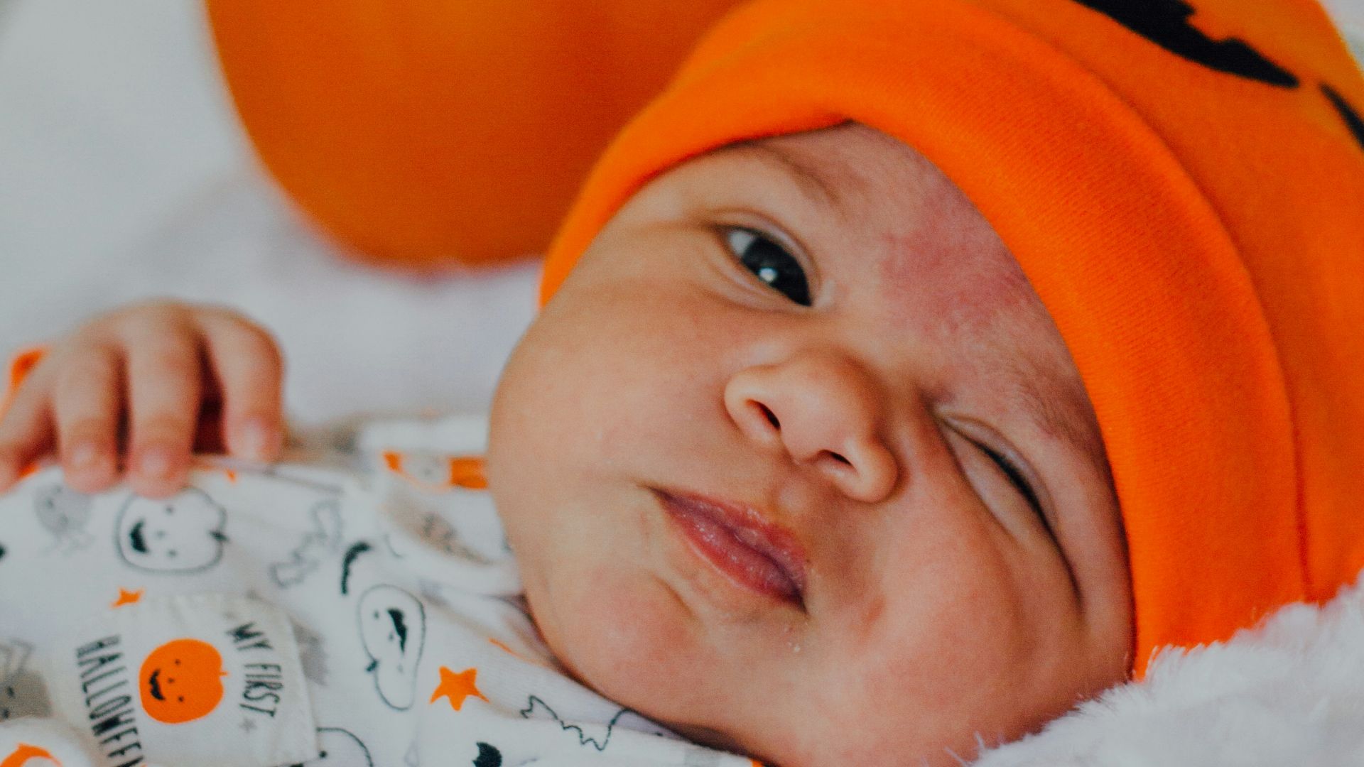 baby wearing orange knit cap