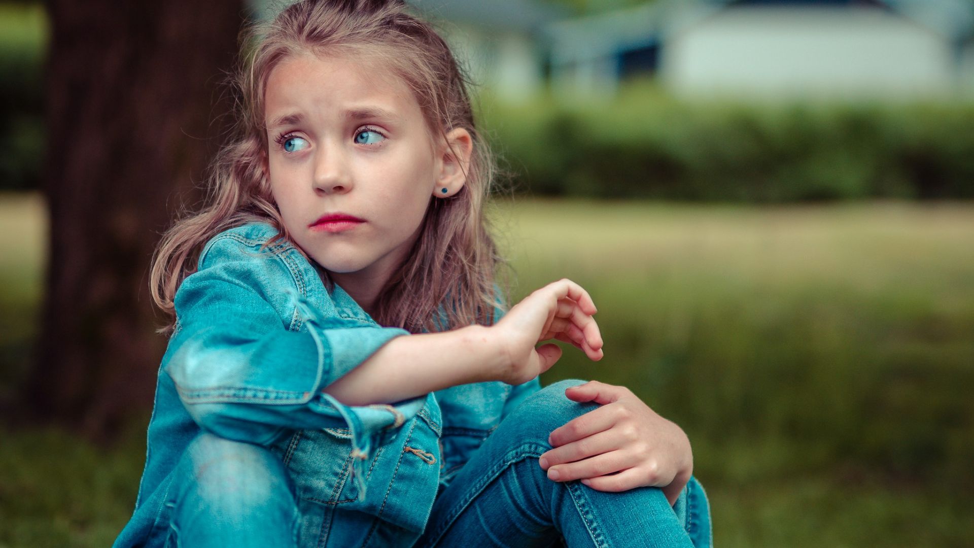 selective focus photography of girl sitting near tree