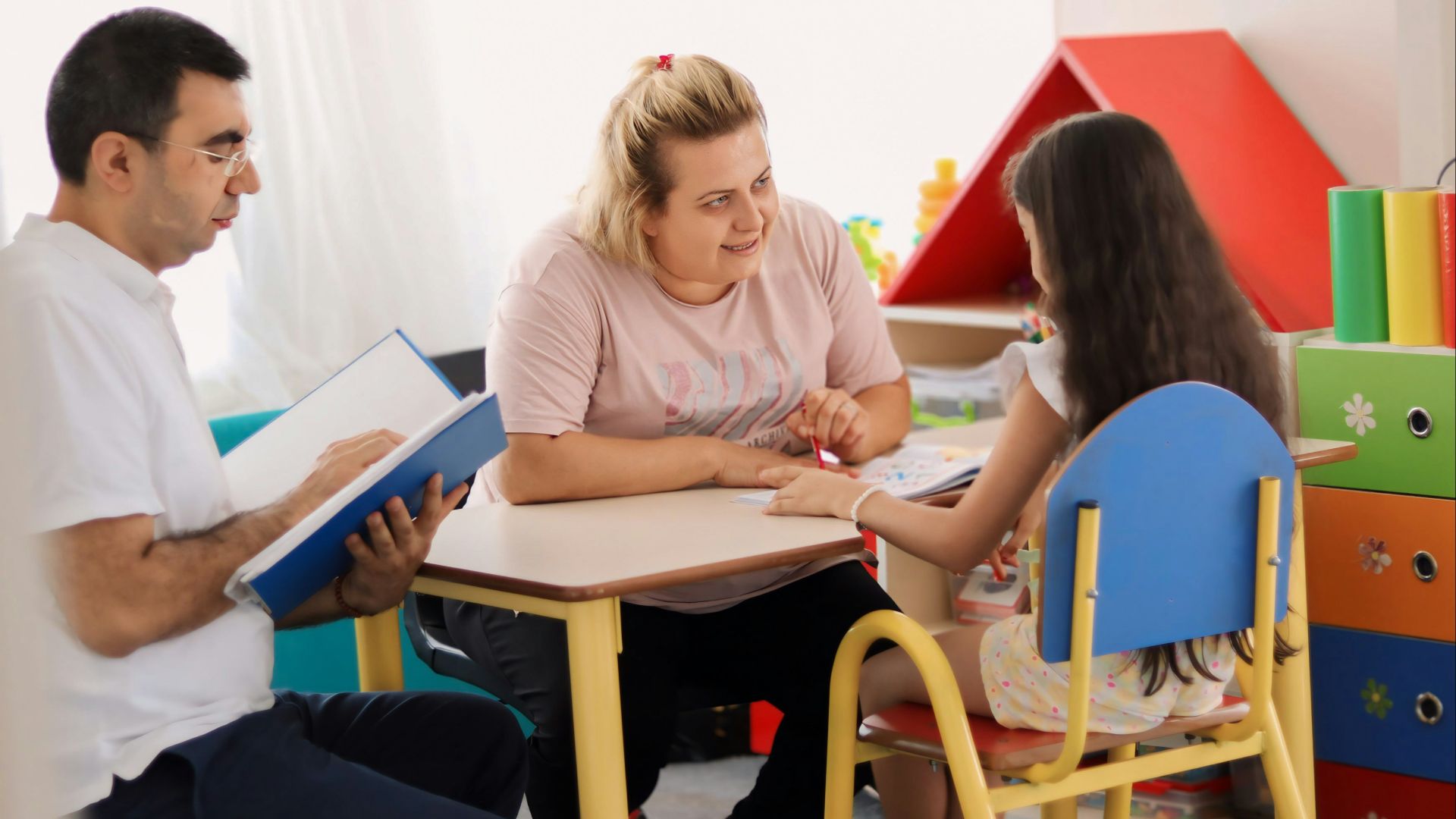 A group of people sitting around a table in a room