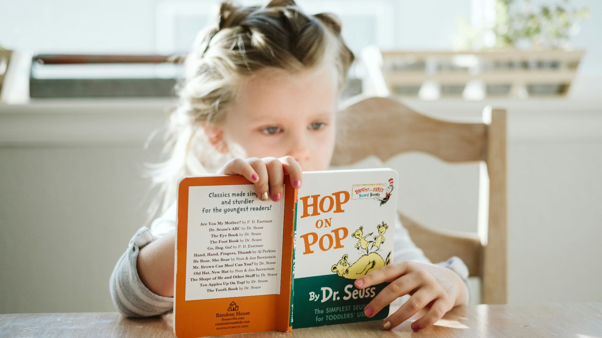 girl sitting while reading book