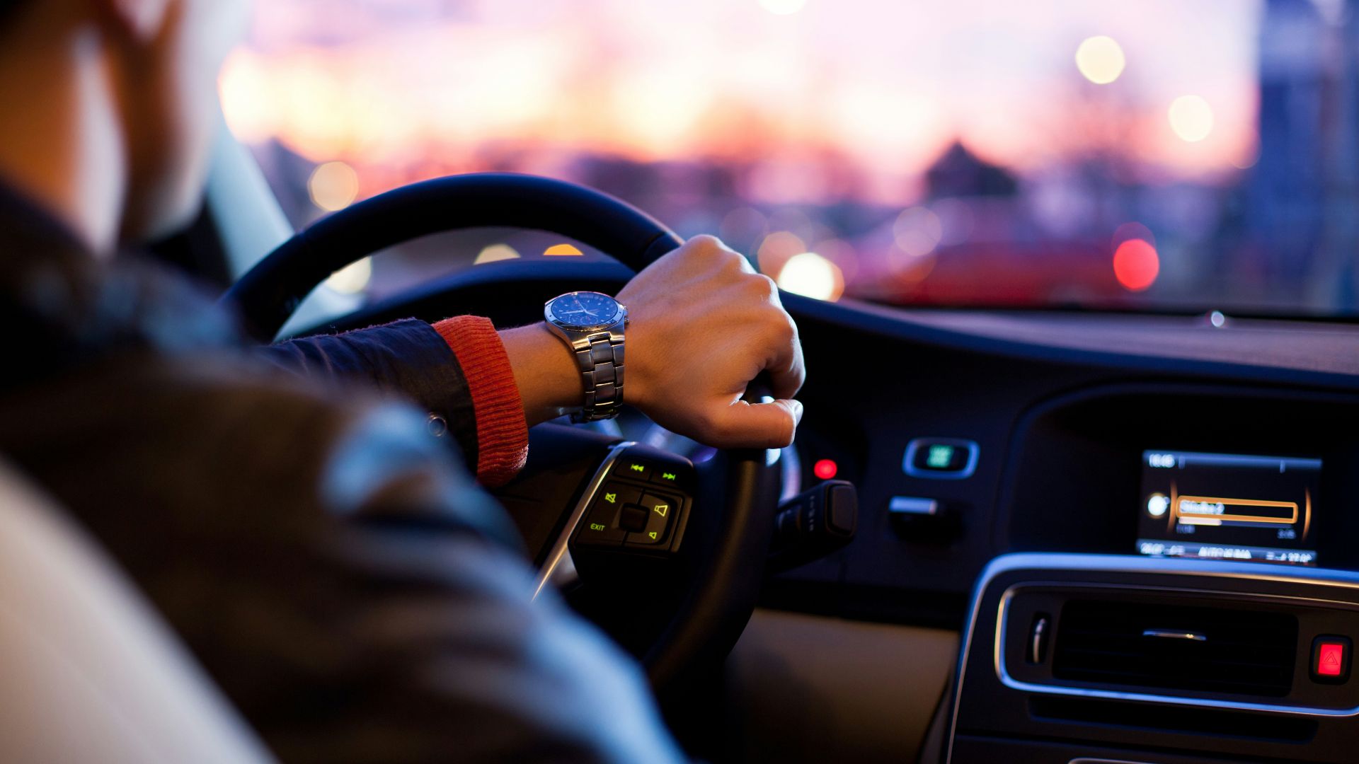 man driving a car wearing wrist watch