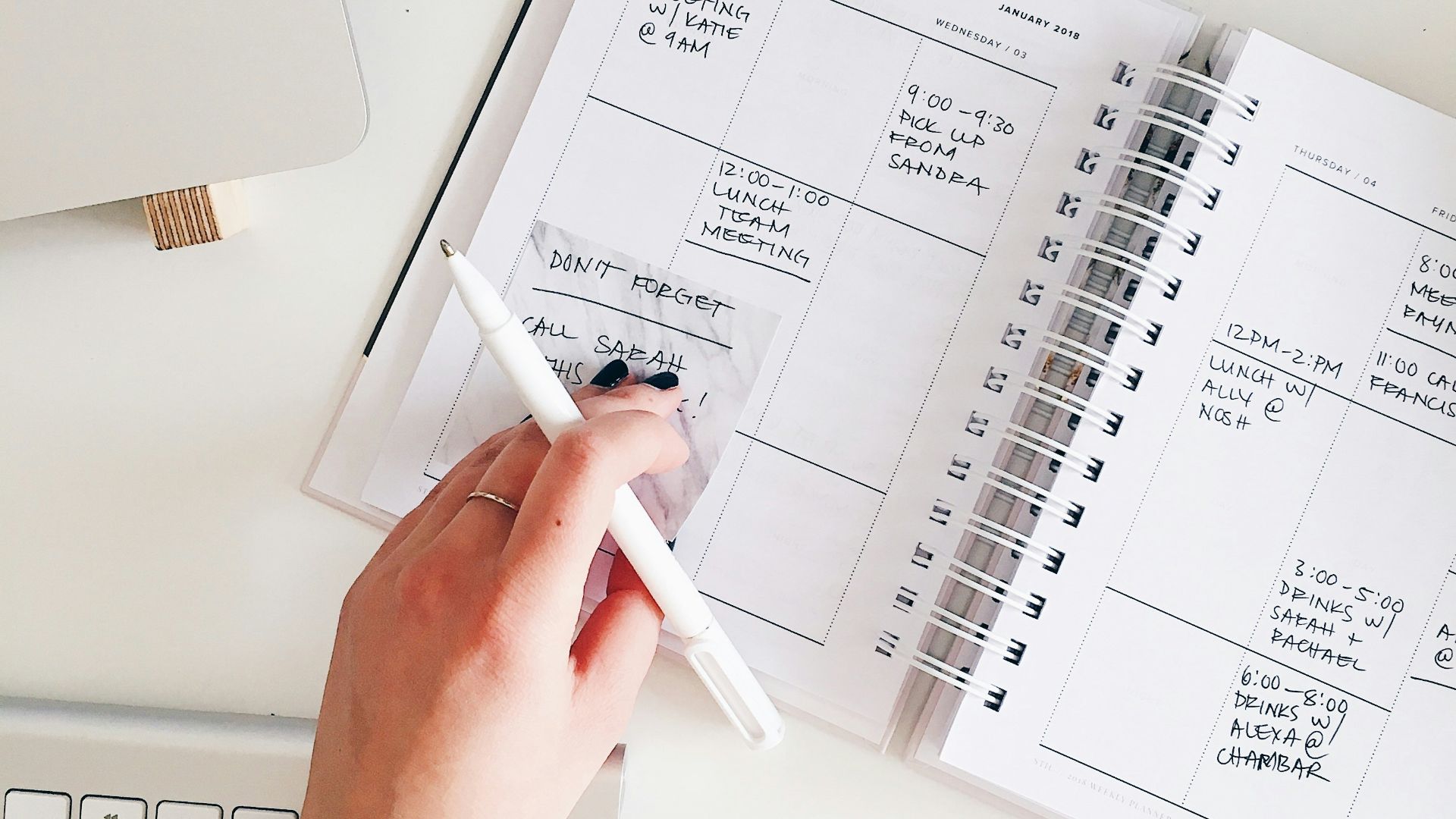 person holding notepad and pen flat lay photography