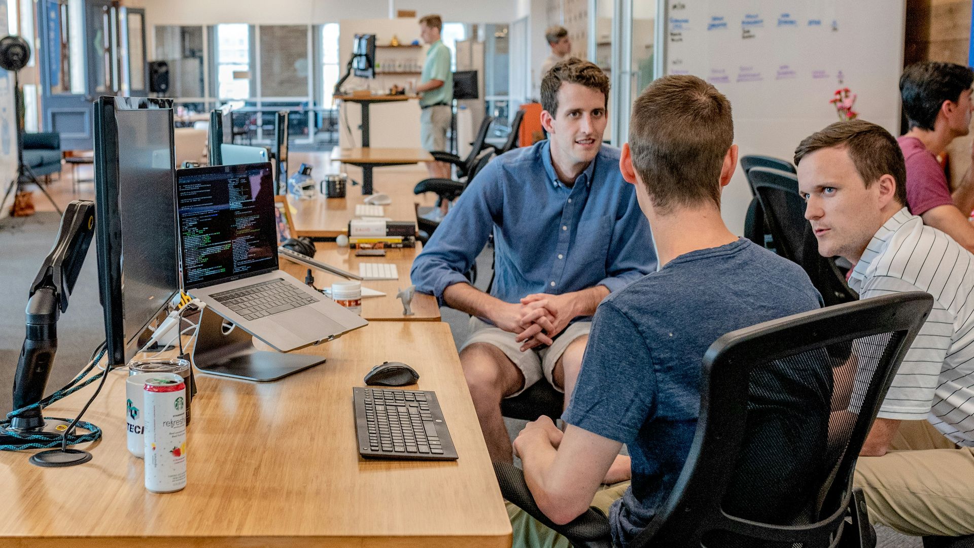 three men sitting on chair beside tables