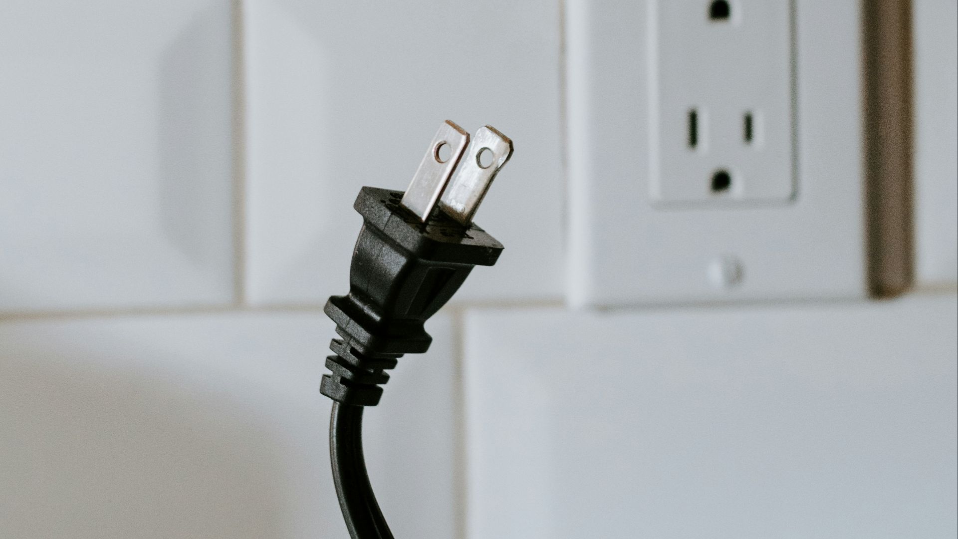 black usb cable plugged in white electric socket