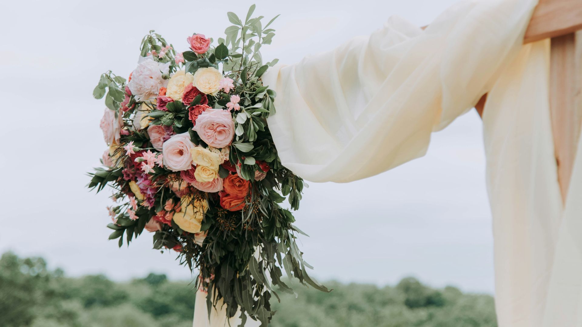 bouquet of assorted-color flowers hanged on brown plank with white textile