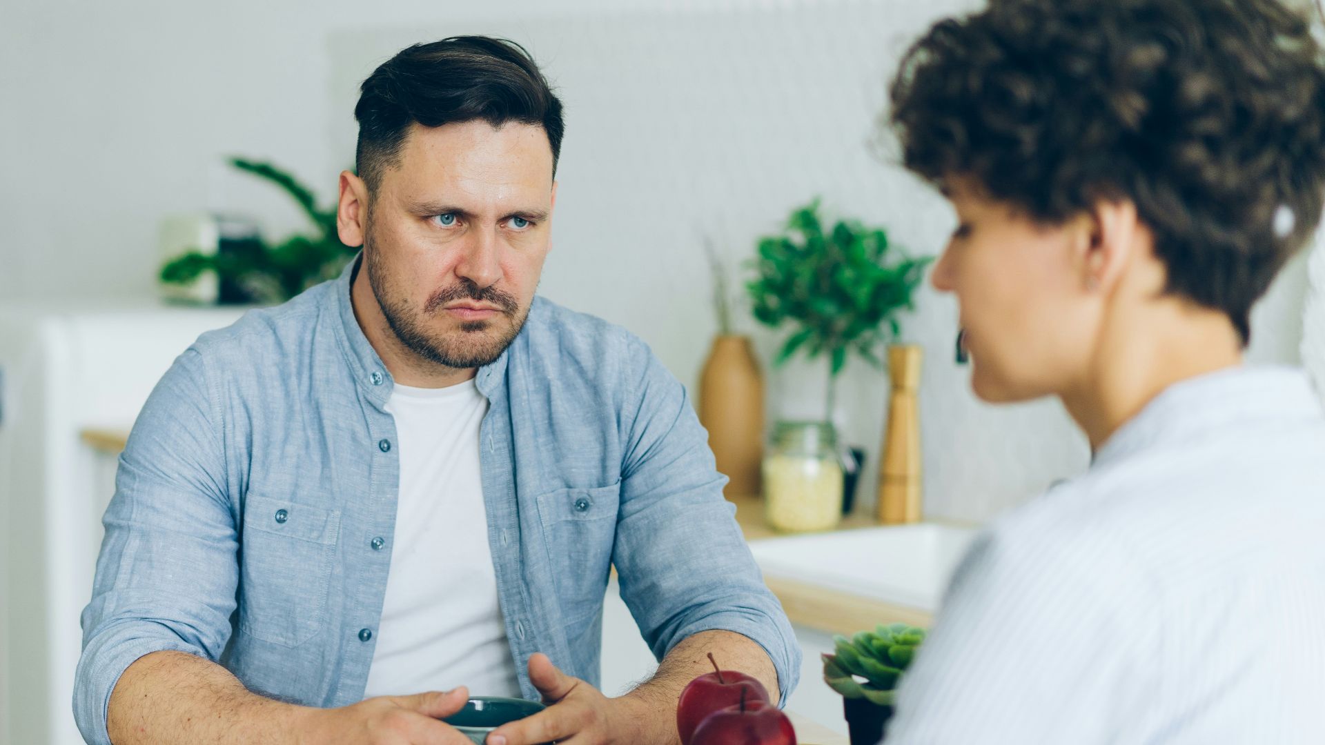 a man sitting at a table talking to a woman