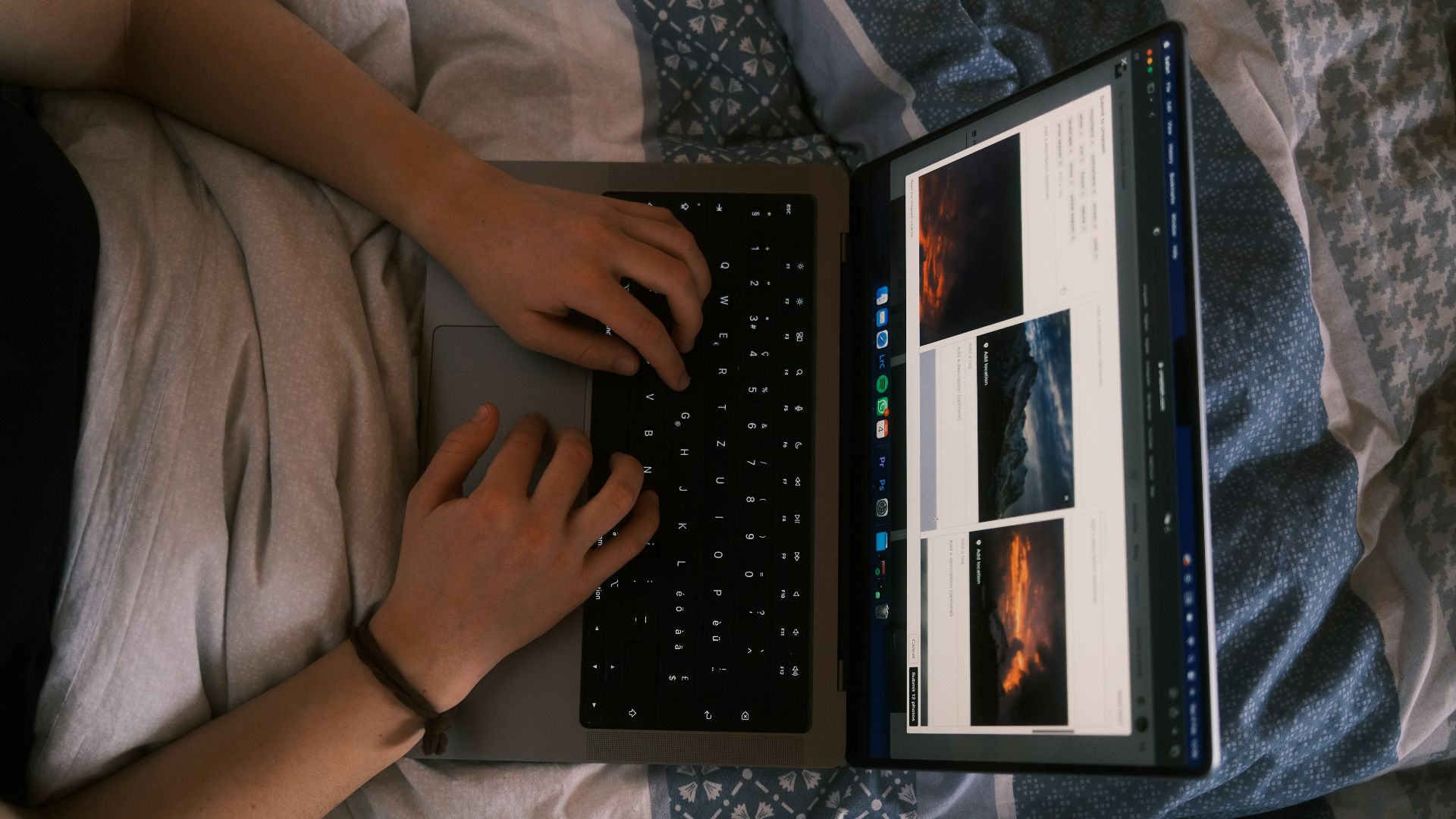 a person using a laptop computer on a bed