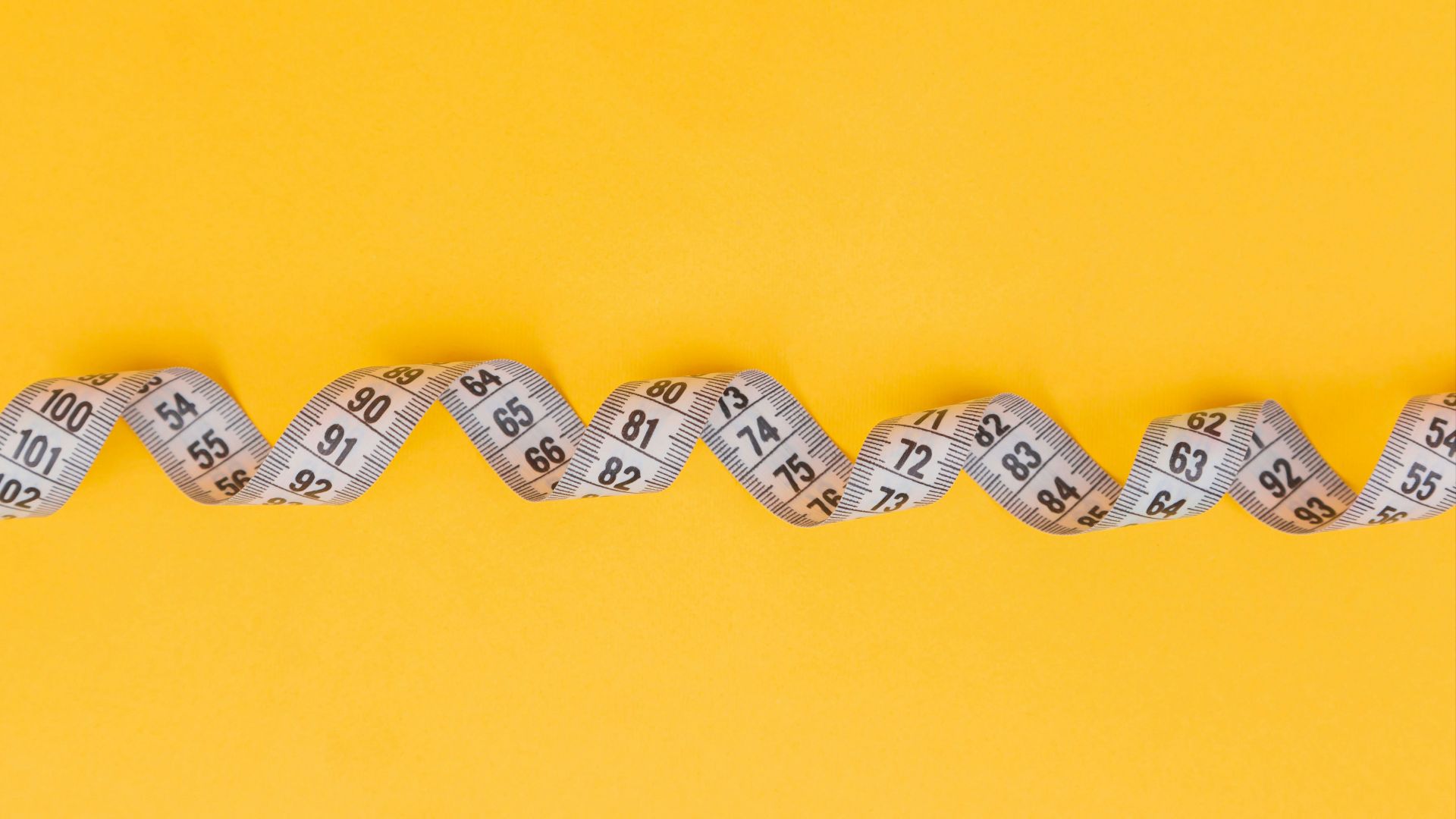 silver and black necklace on yellow textile