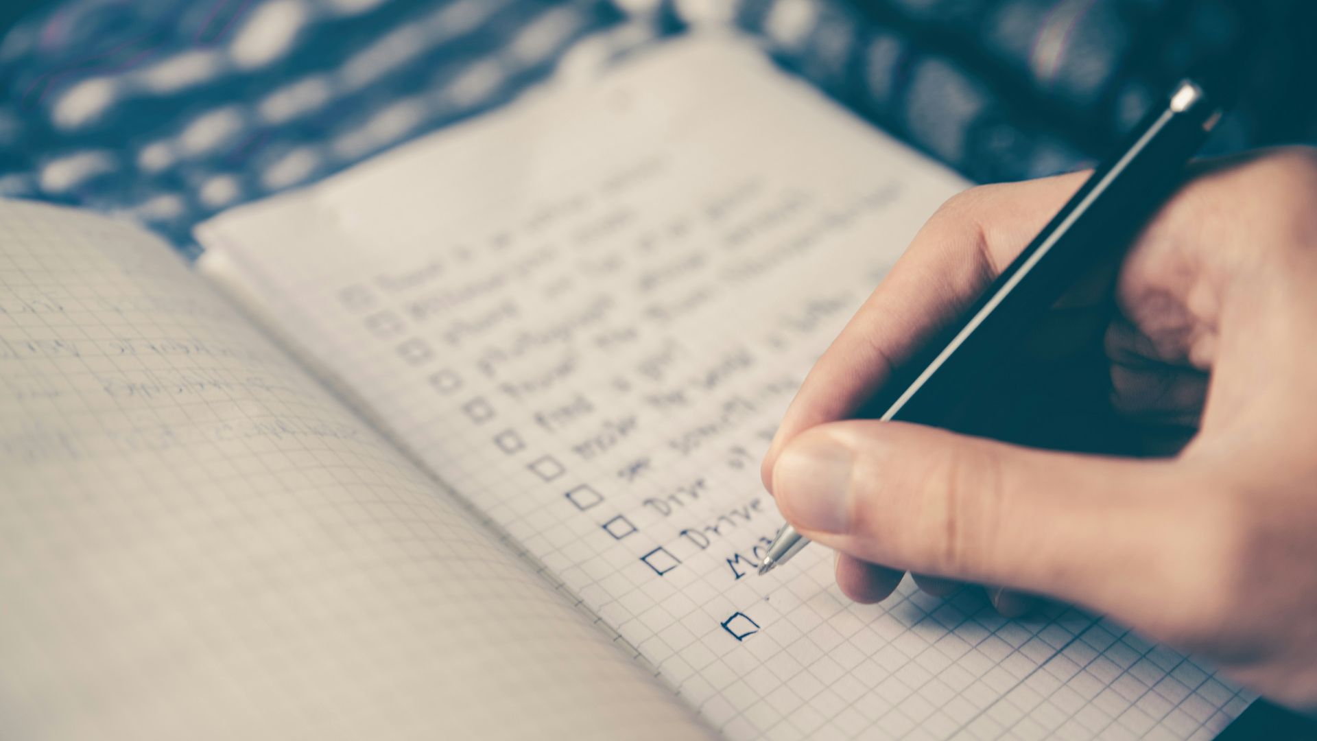 person writing bucket list on book