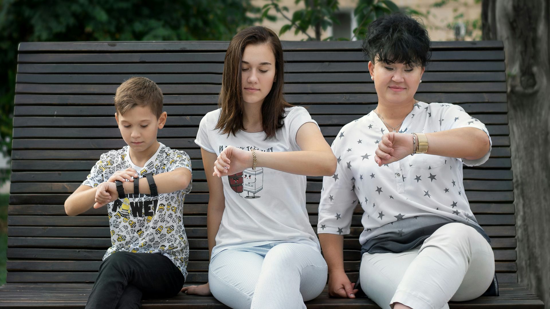 man and woman sitting on brown wooden bench