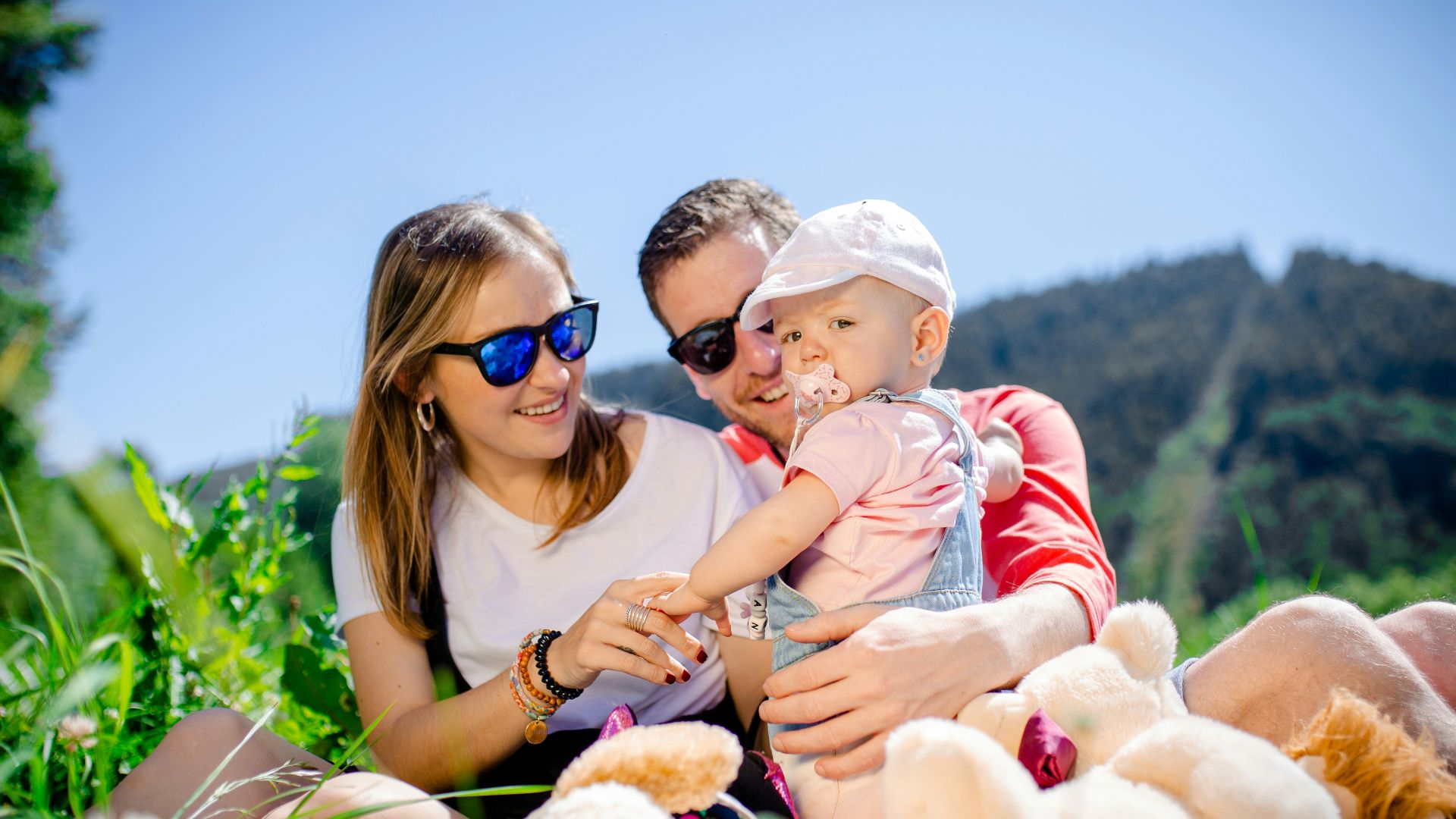 woman in white shirt carrying baby in white and red stripe shirt