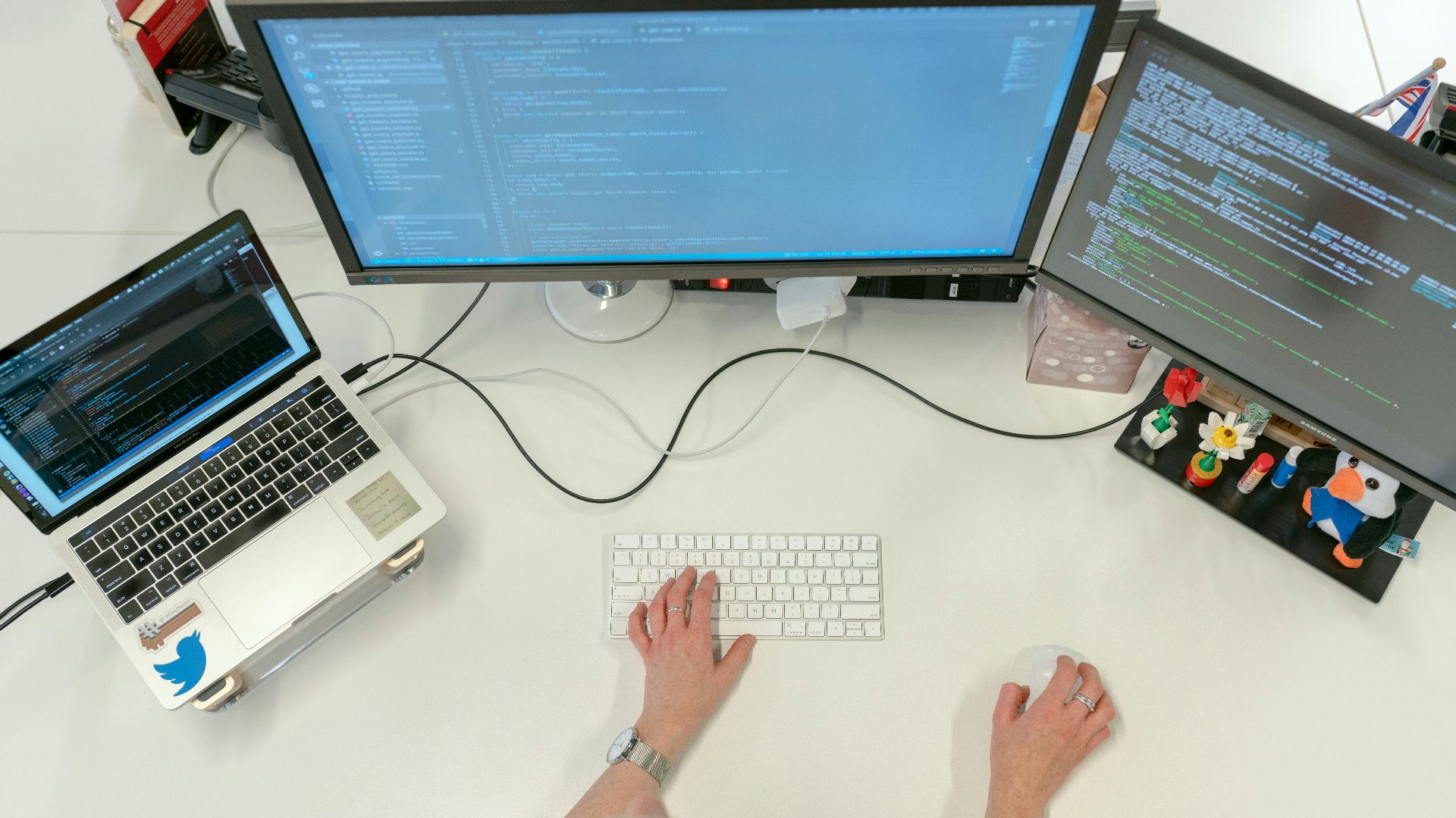 person using macbook pro on white table