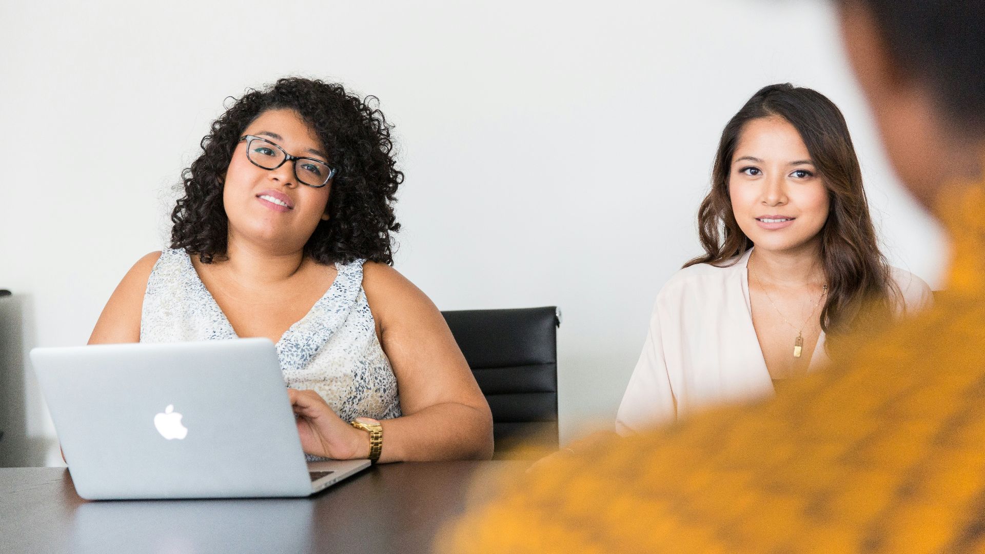 two women looking at person across the table