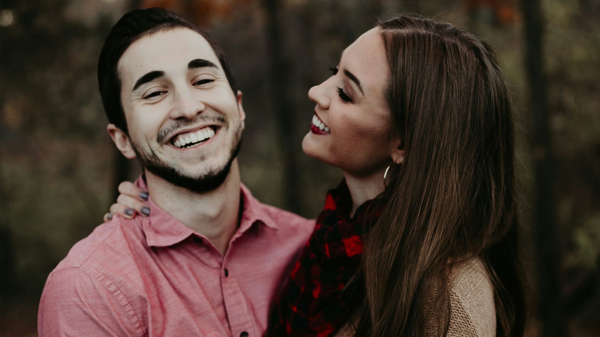 woman hugging man selective focus photography