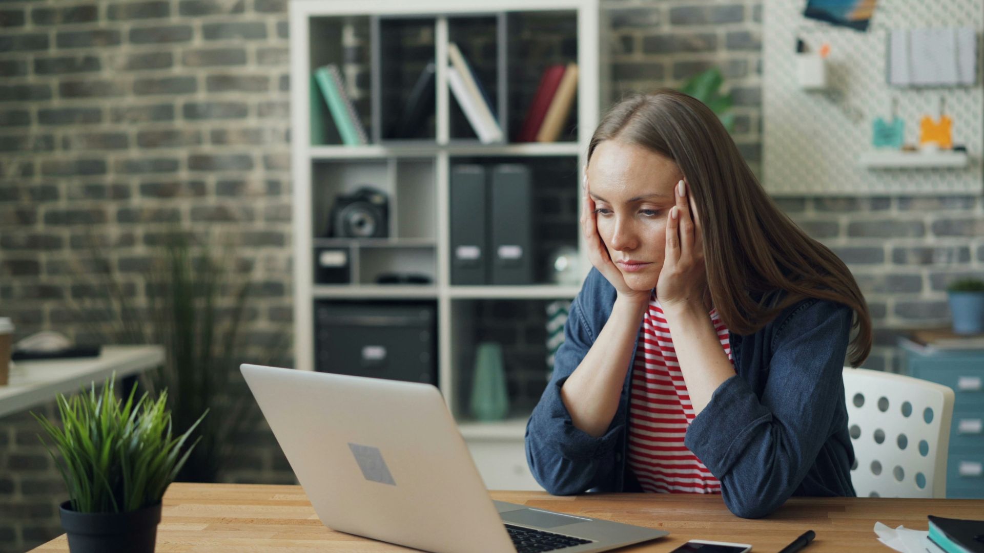 a woman sitting at a table with a laptop in front of her