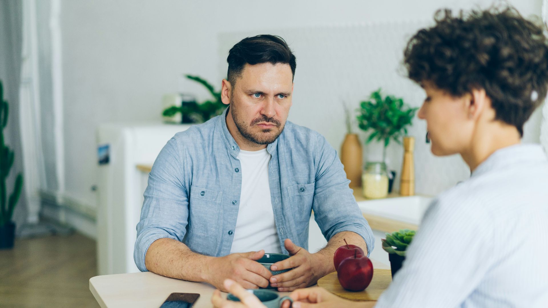 a man sitting at a table talking to a woman