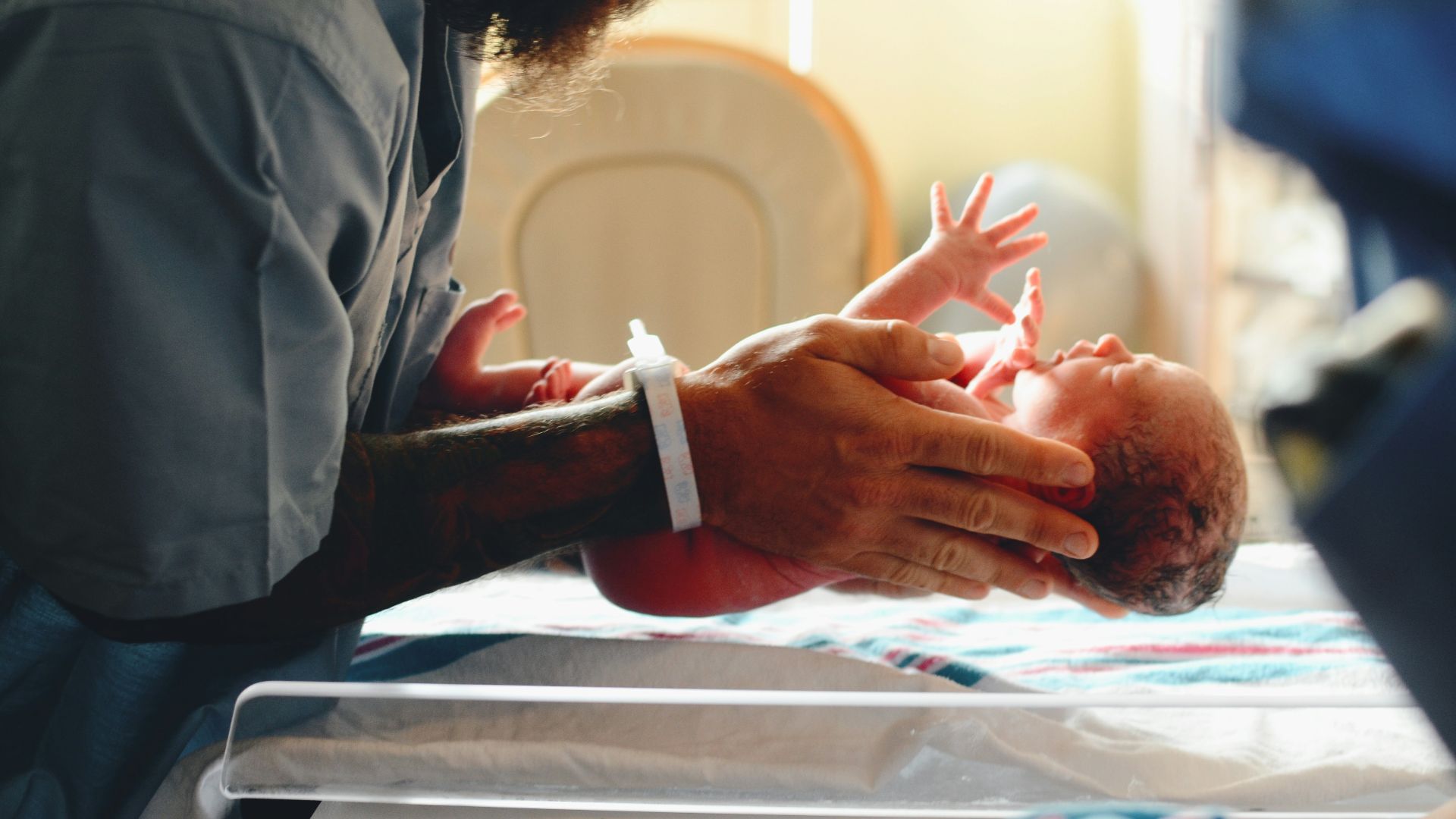 person wearing gray shirt putting baby on scale