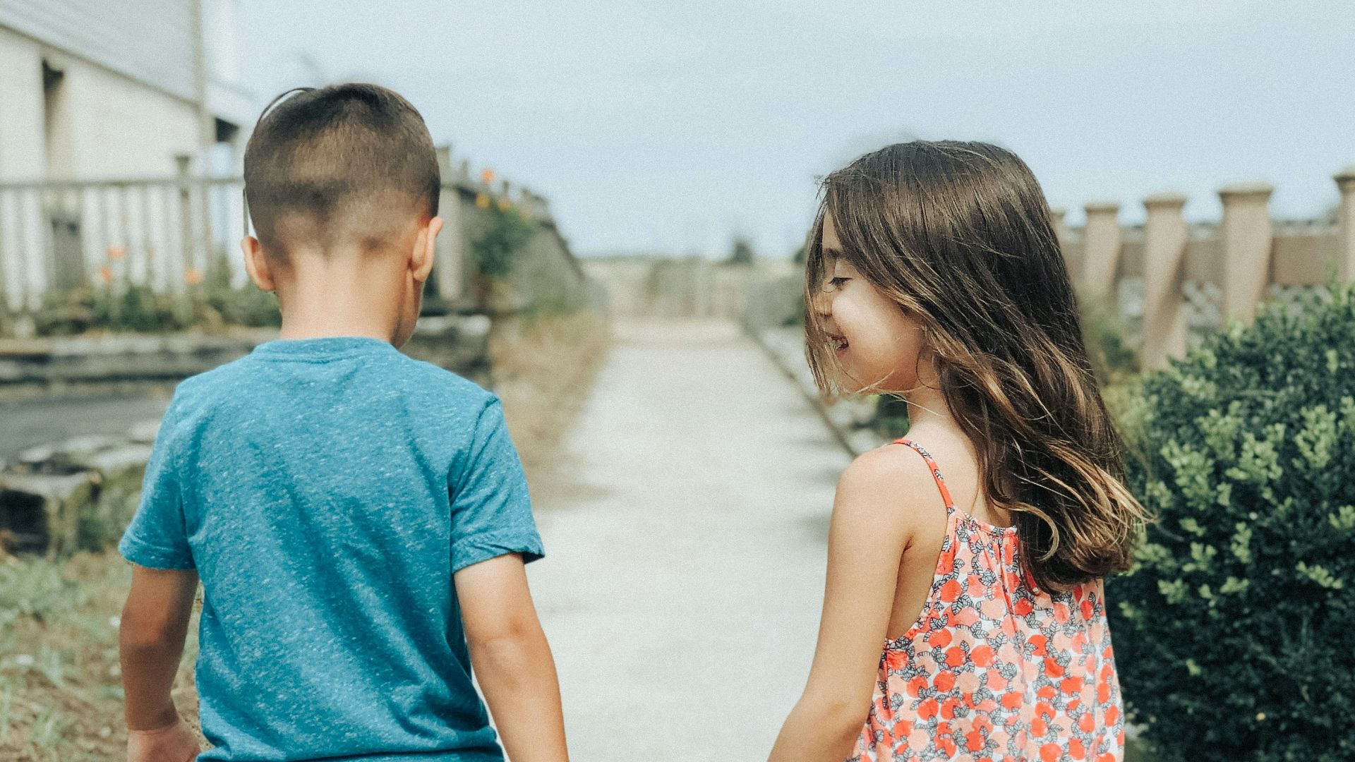 man in blue crew neck t-shirt and woman in red and white floral dress walking
