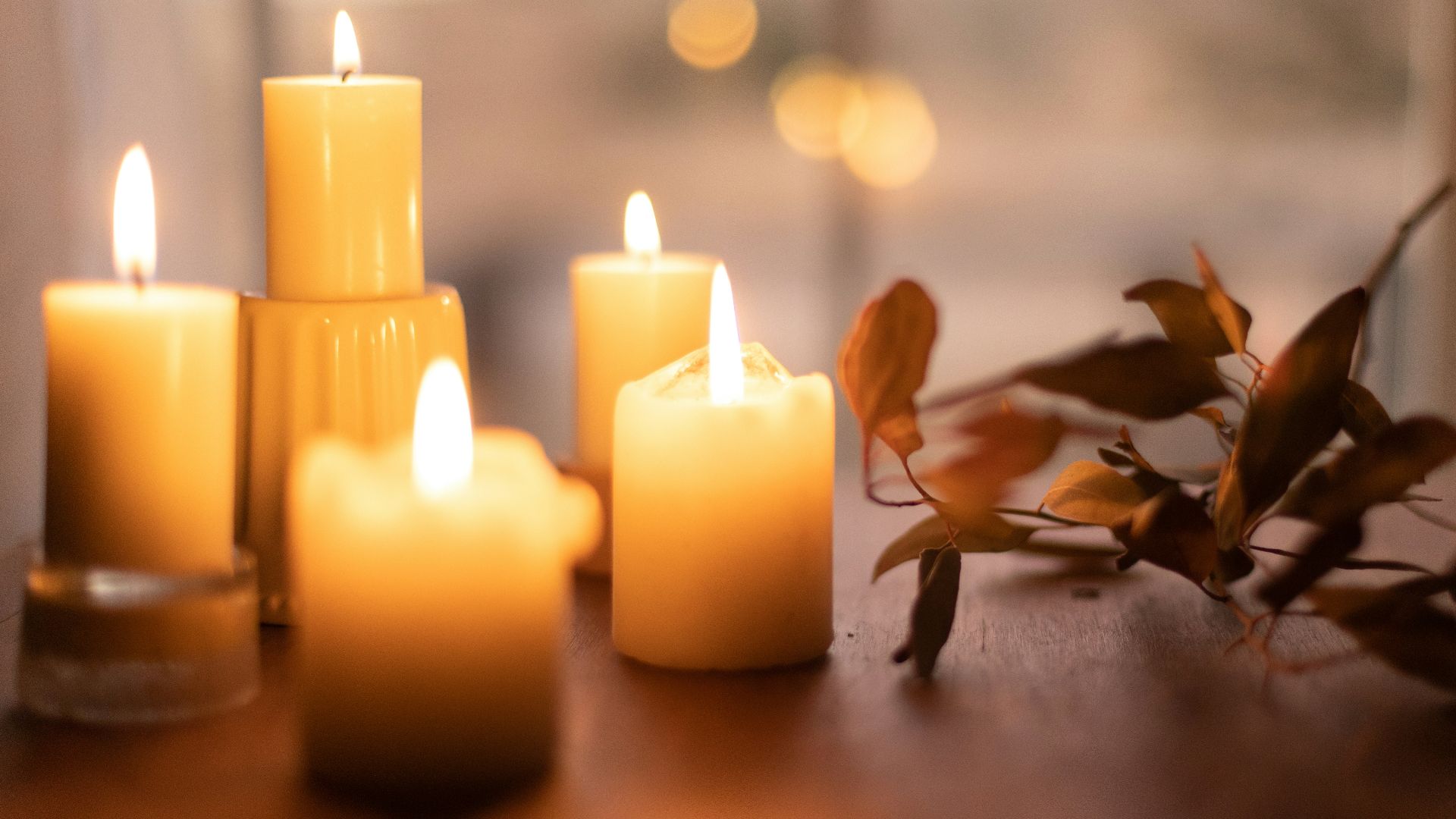 white pillar candles on brown wooden table