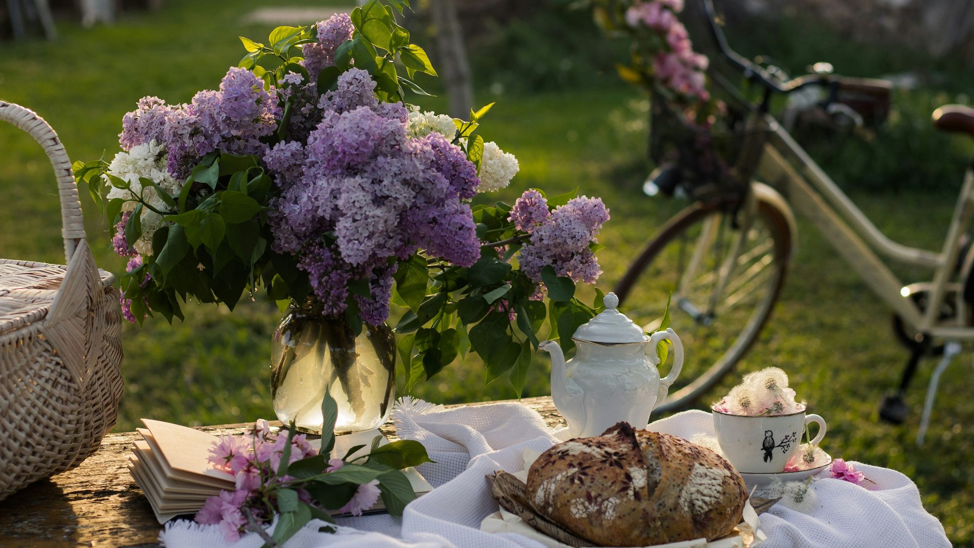a table topped with a basket of flowers next to a bike