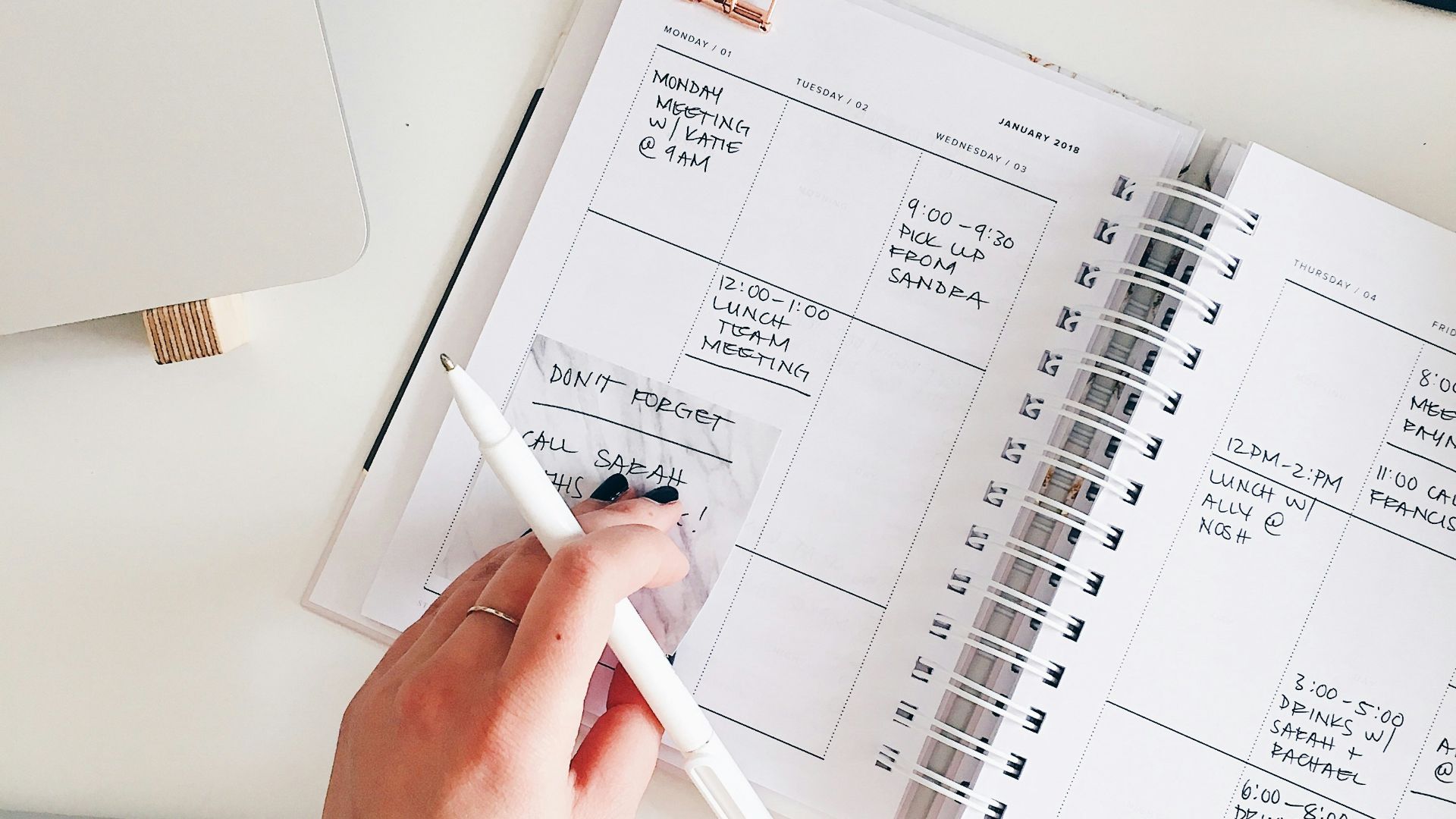 person holding notepad and pen flat lay photography