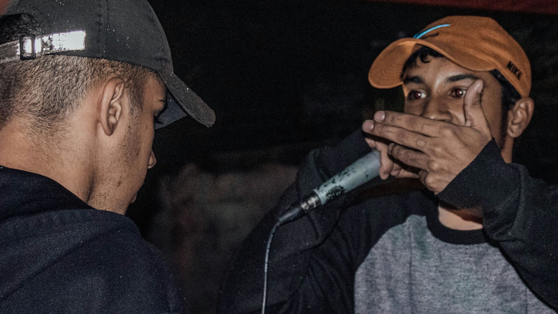 A man standing next to another man holding a microphone