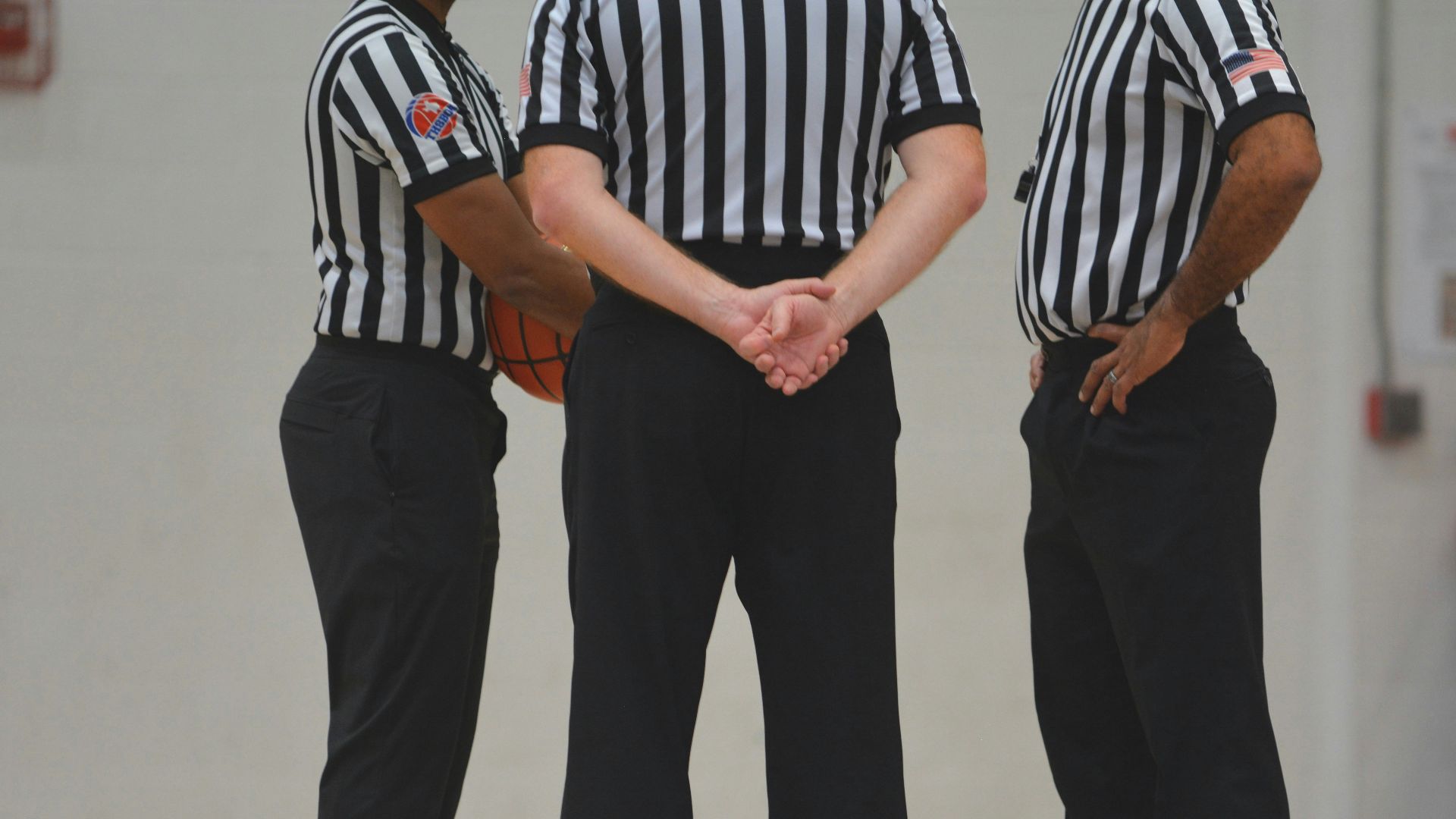 A group of men standing on top of a basketball court