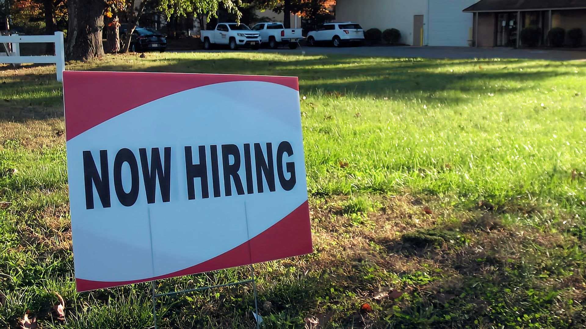 a now hiring sign in front of a building