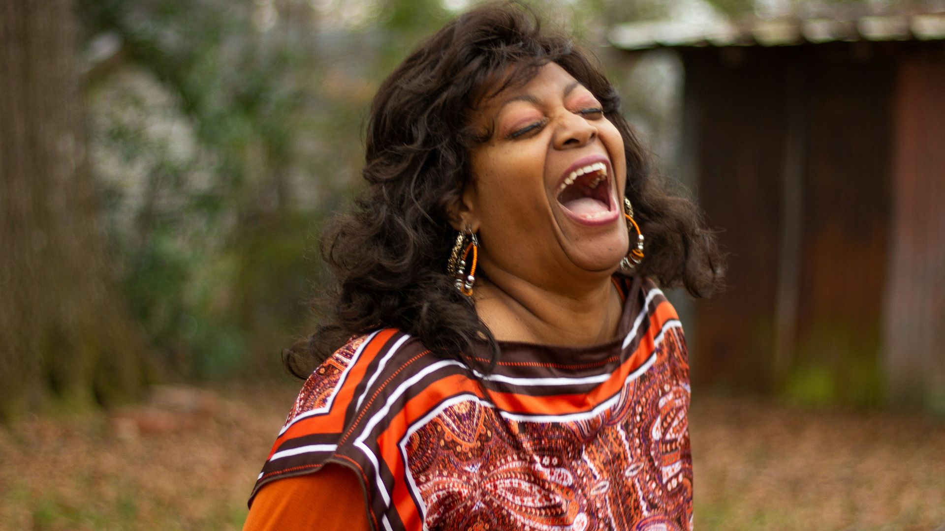woman in orange and black dress smiling