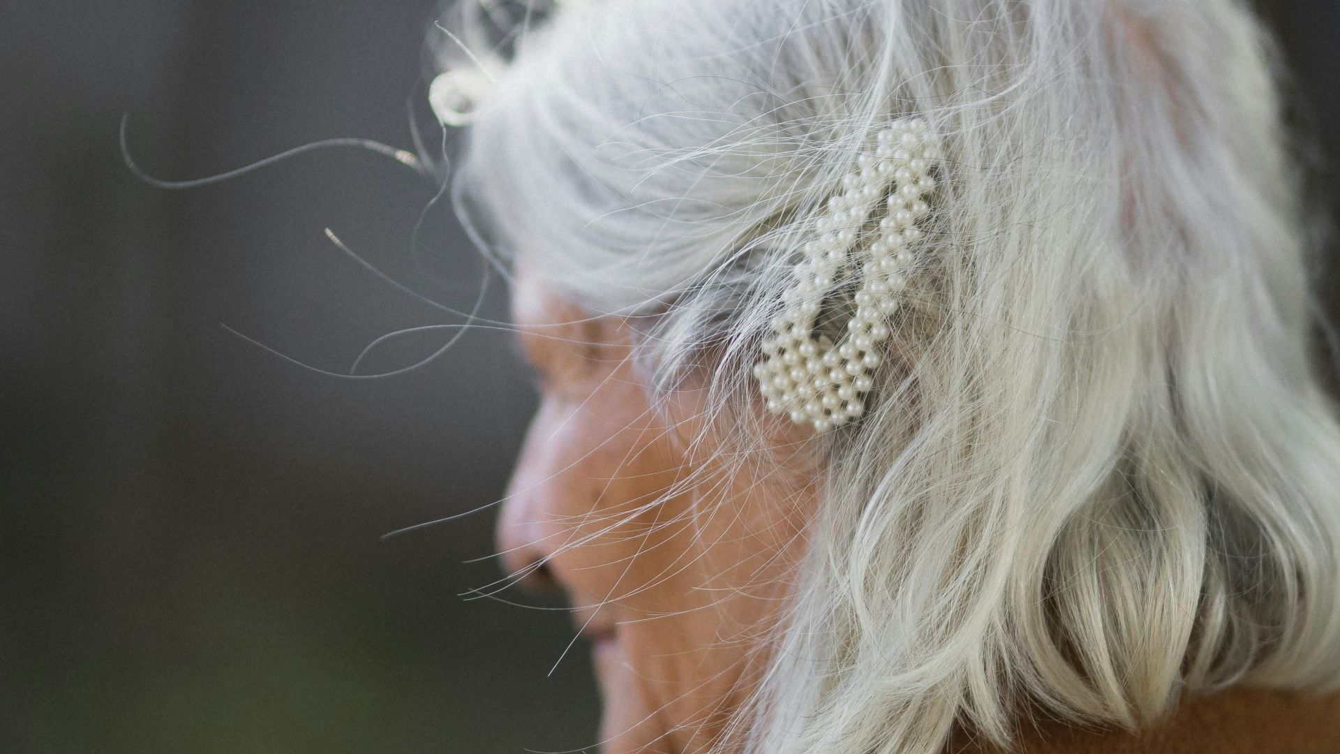 a woman with white hair and a bow in her hair