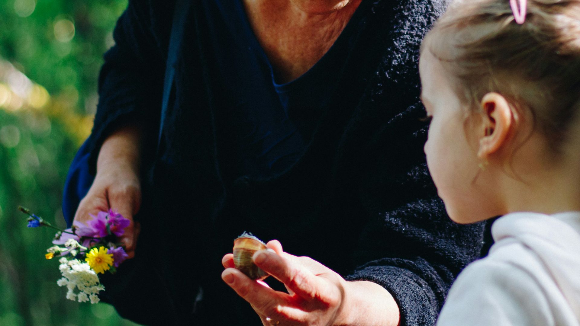 woman in black long sleeve shirt holding purple flower
