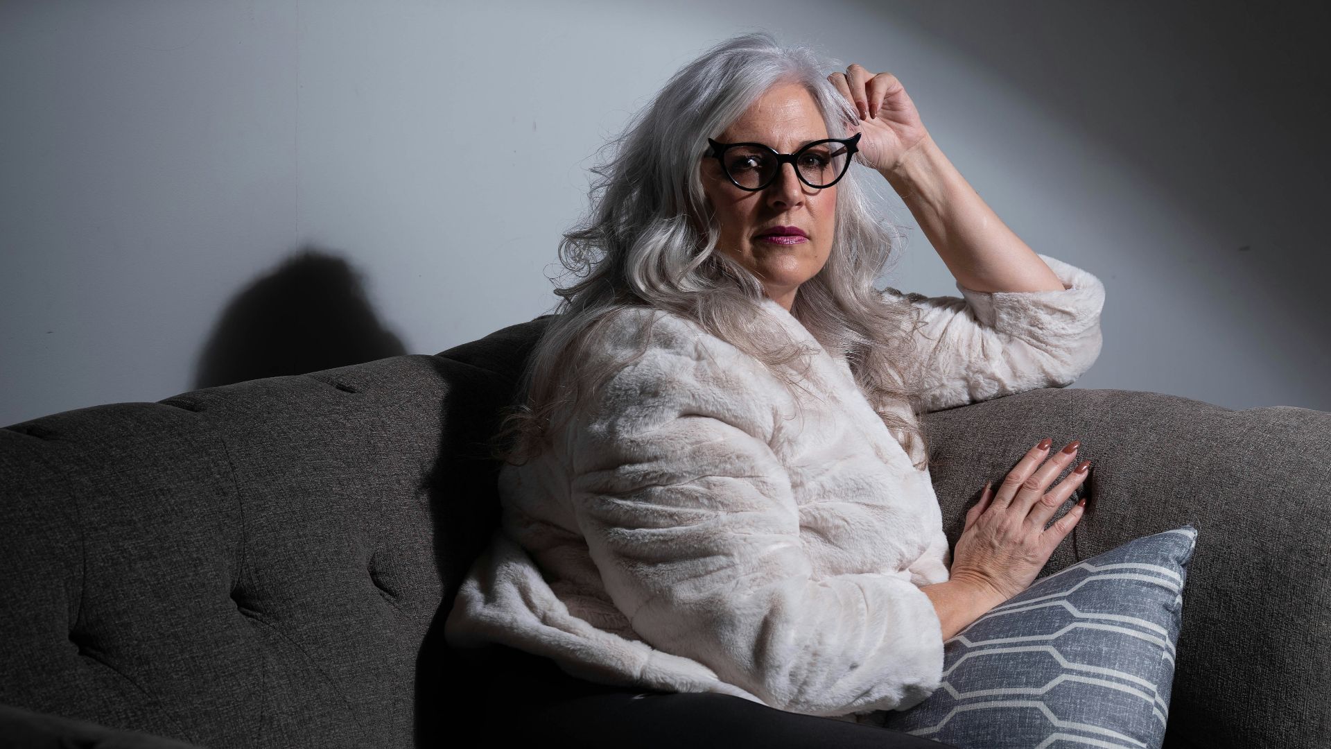 woman in white long sleeve shirt and black pants sitting on black sofa