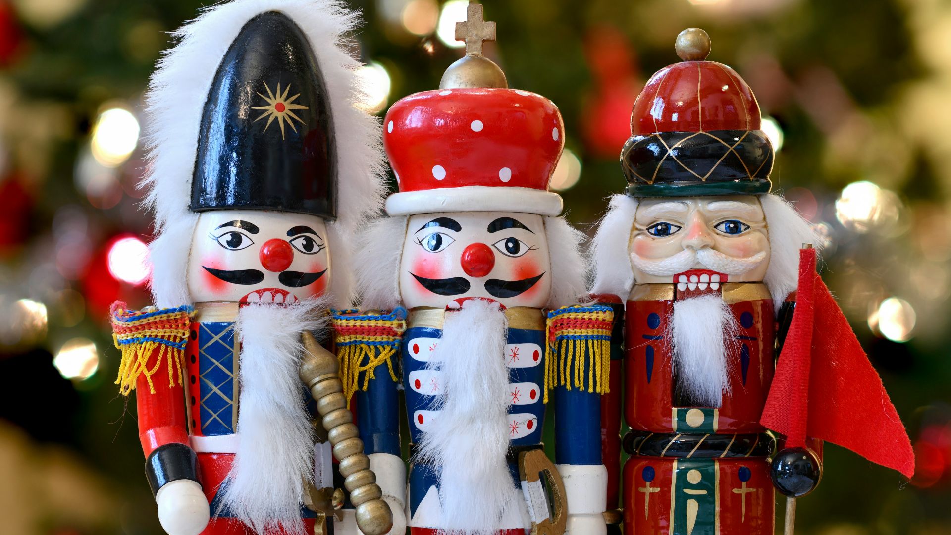 a group of nutcrackers standing next to a christmas tree