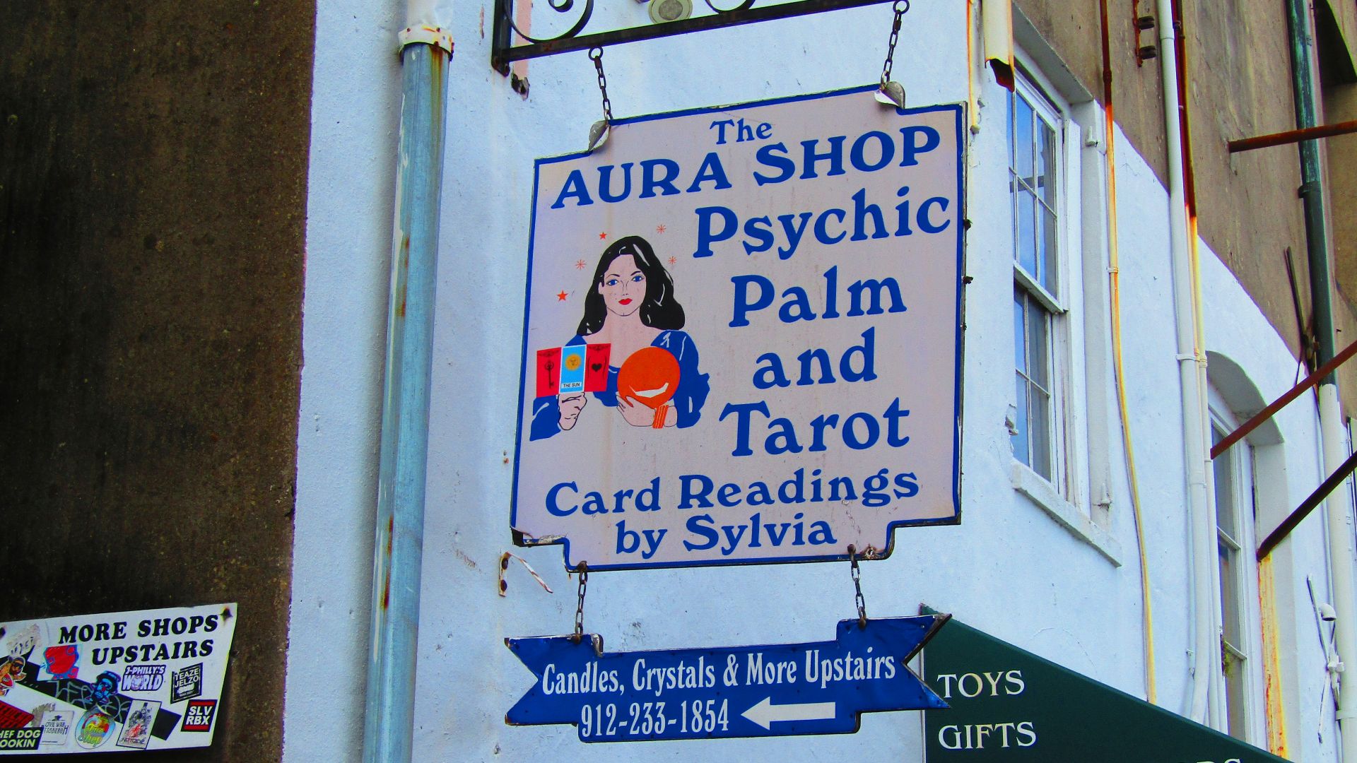 a sign on the side of a building that says aura shop psychic palm and tar