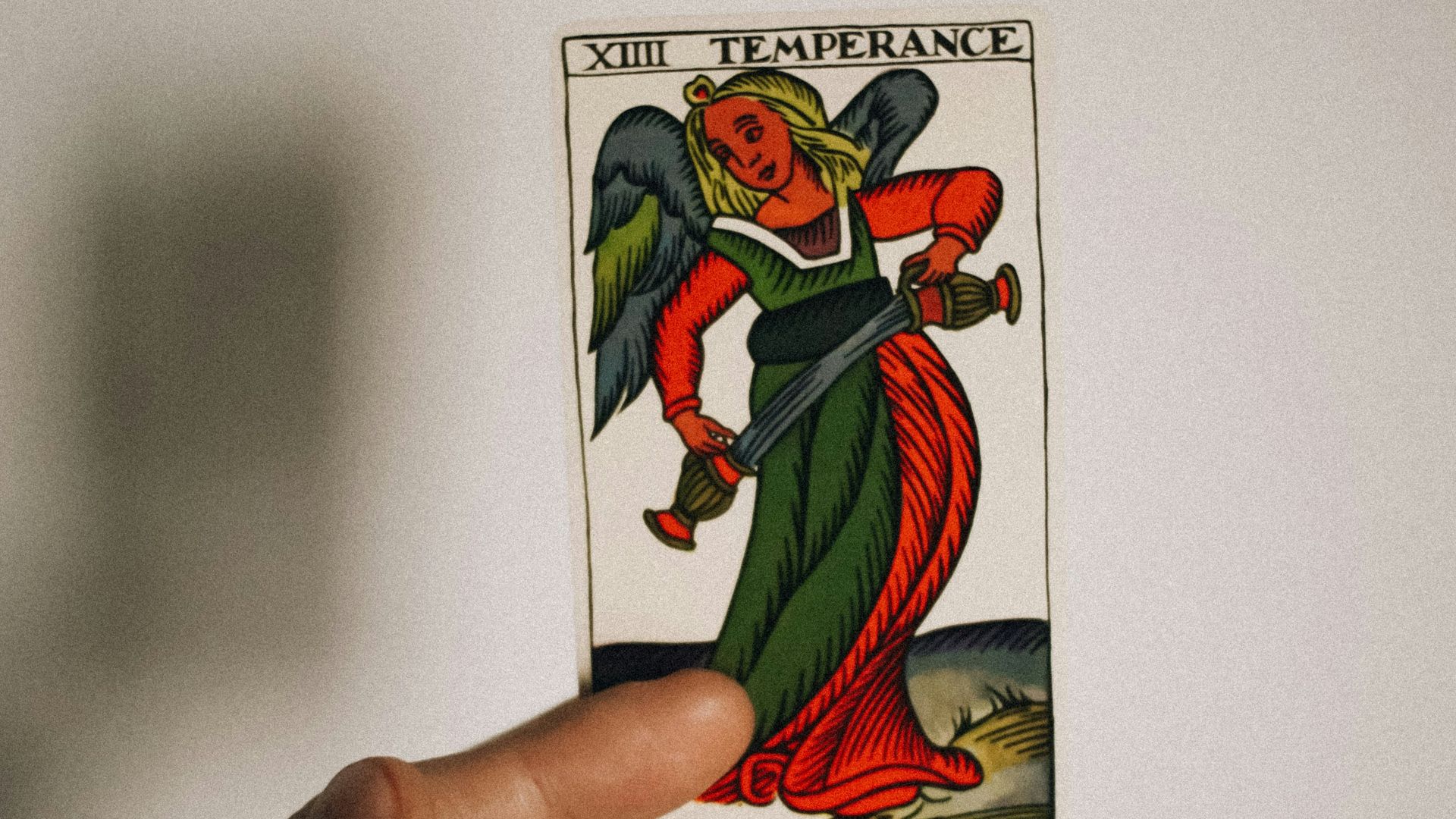 a person holding up a card with a devil on it