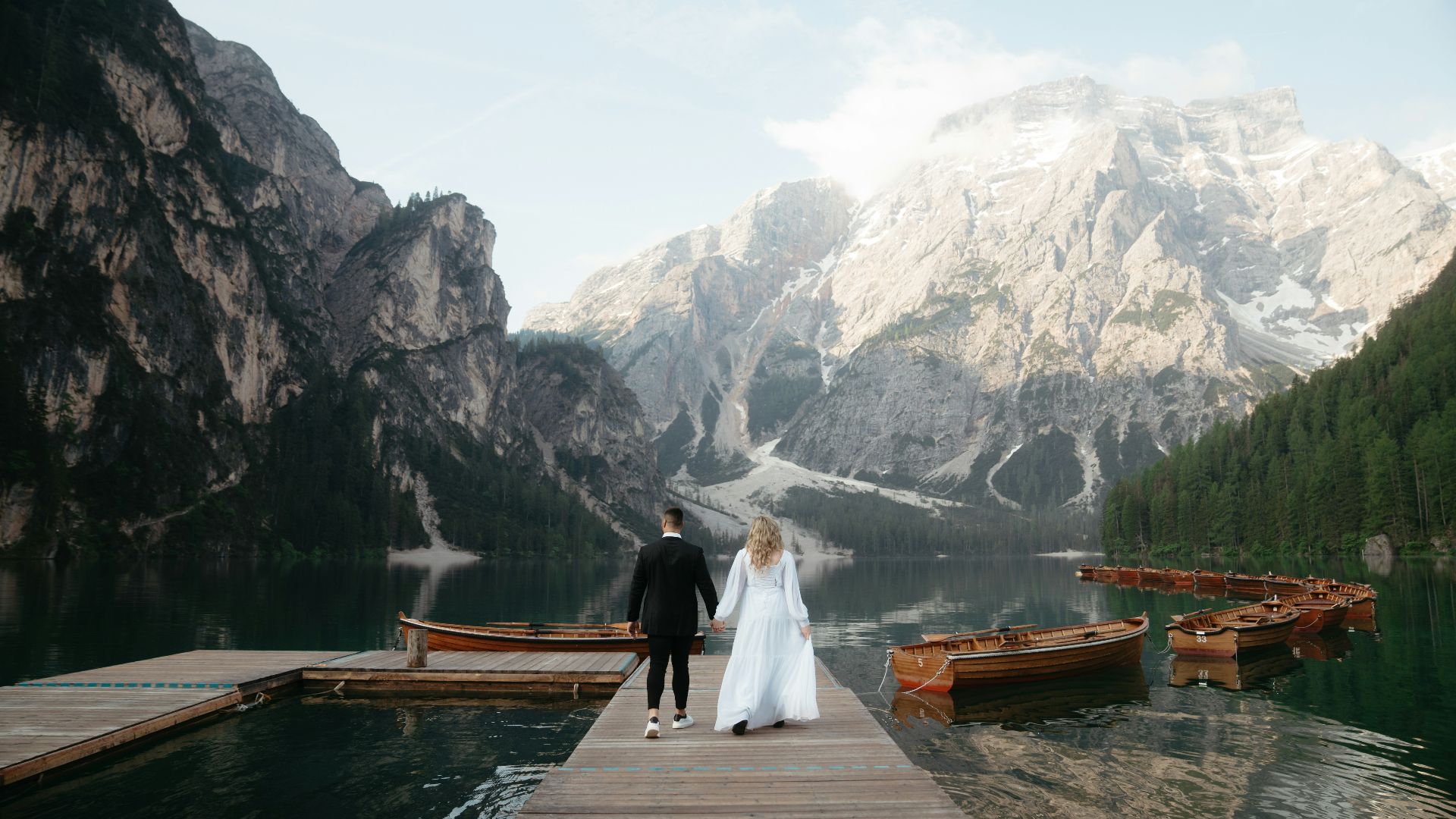 A bride and groom are standing on a dock