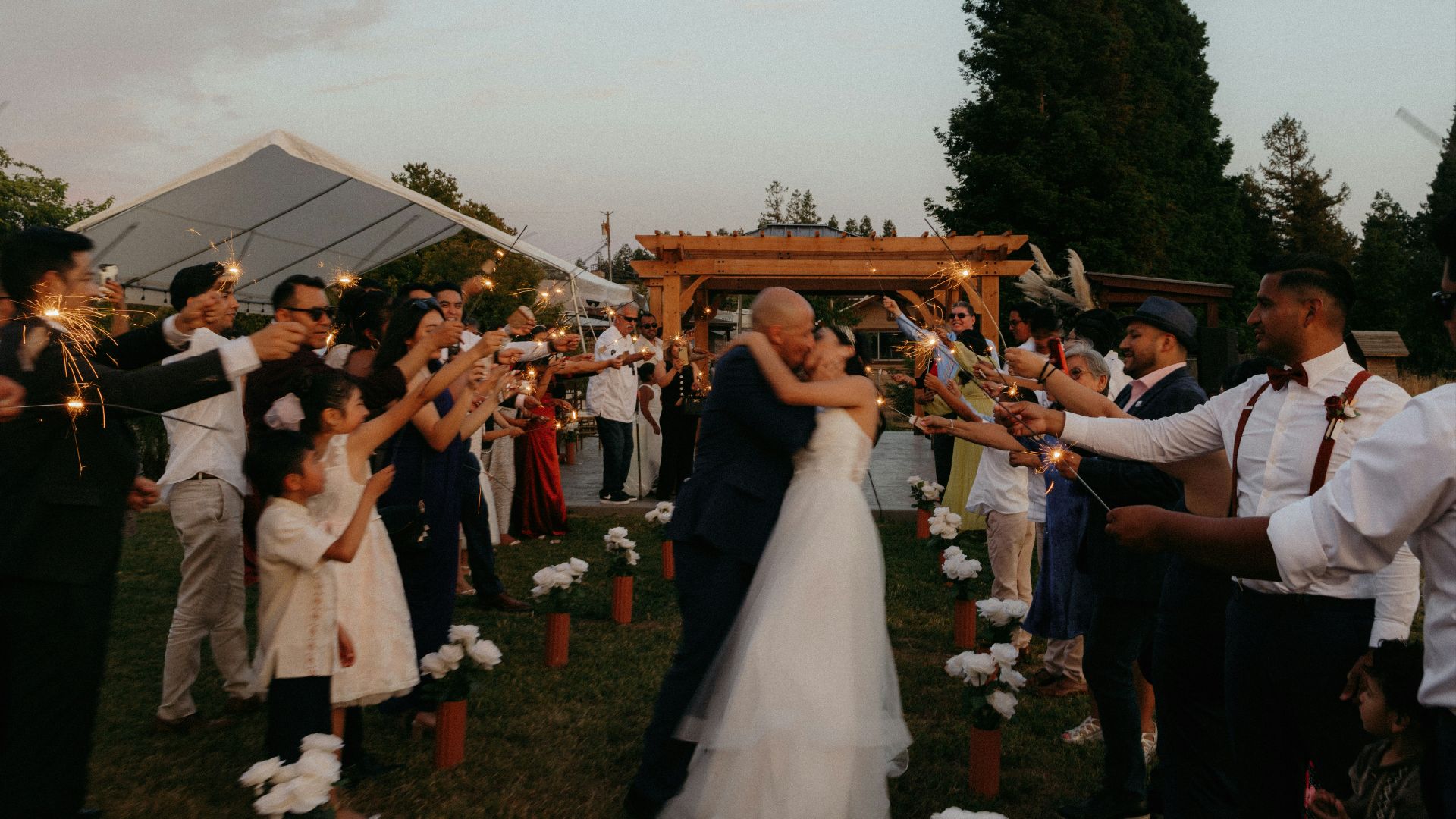 A bride and groom are surrounded by their guests