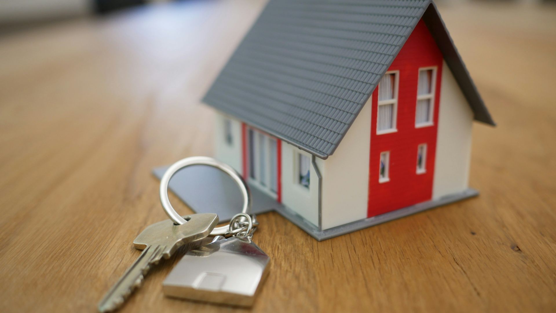 white and red wooden house miniature on brown table